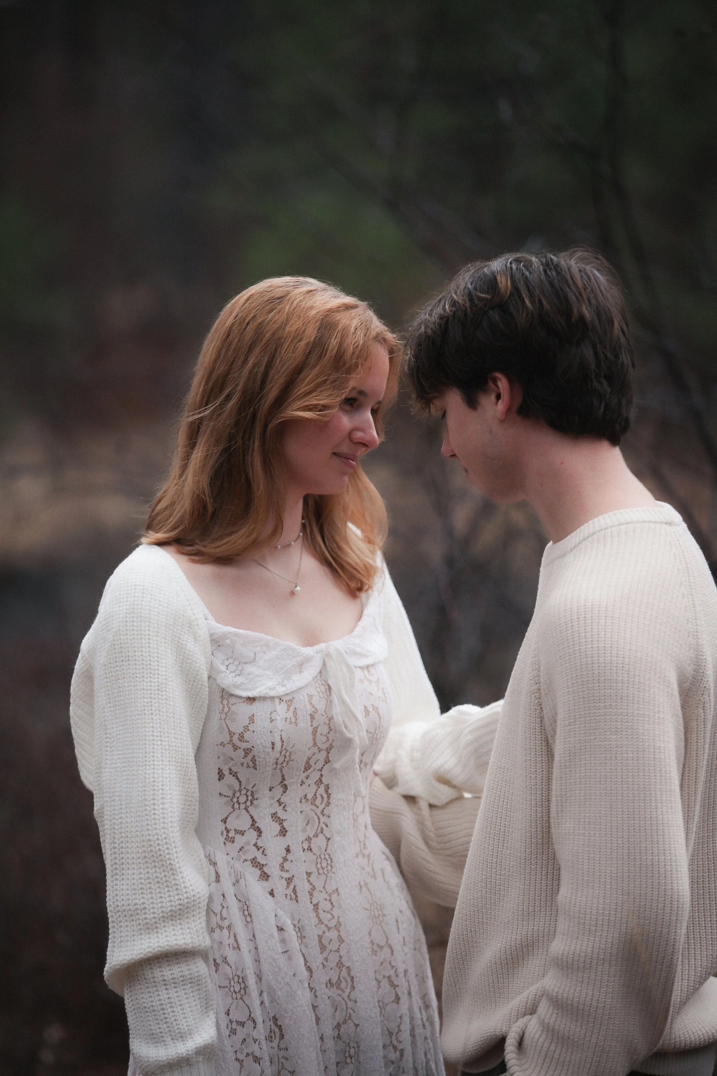 Editorial engagement photo of a bride and groom surrounded by the evergreen landscape near Sisters, Oregon.