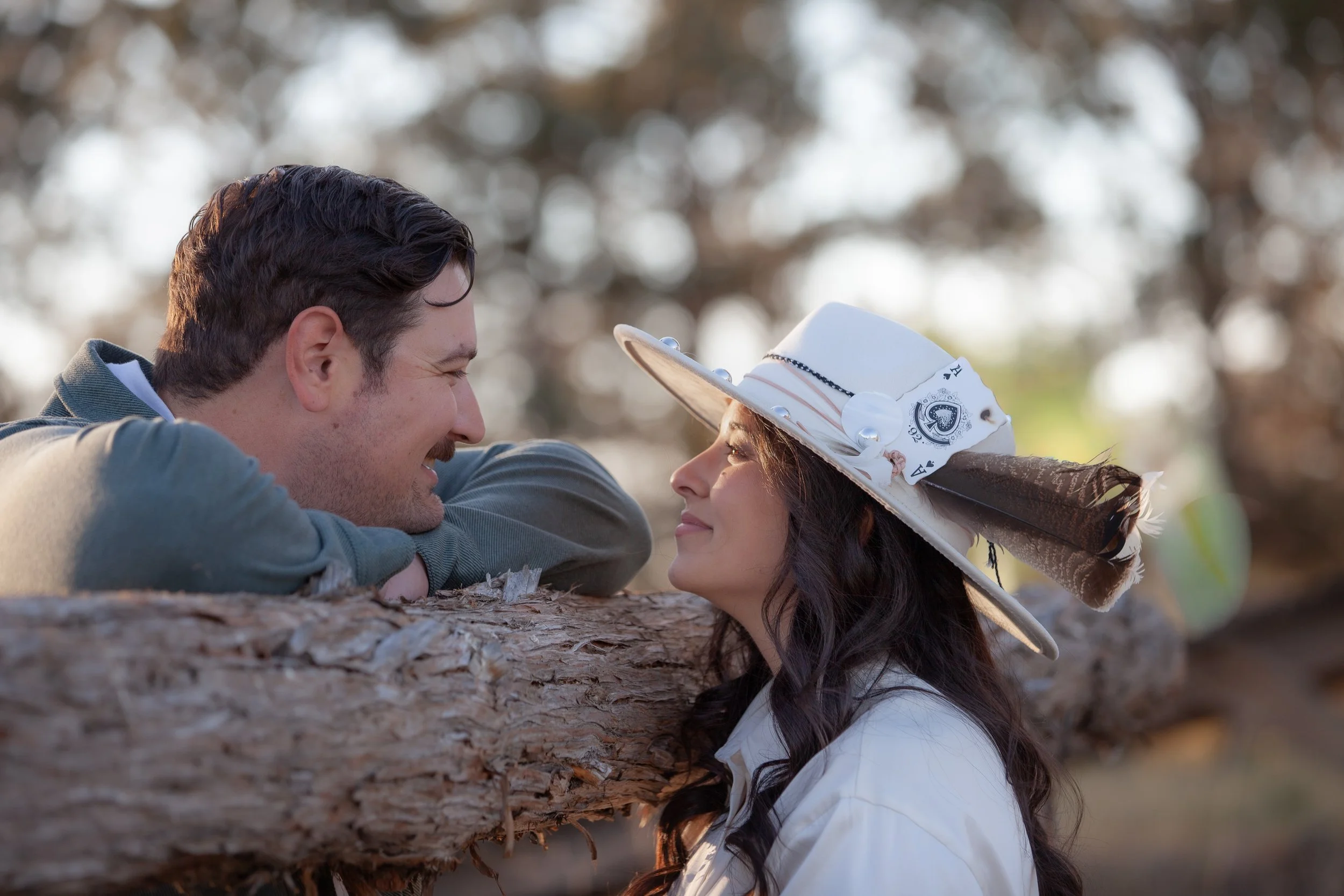 Bride-to-be adjusting her Western hat during engagement photos on a private Central Oregon ranch.