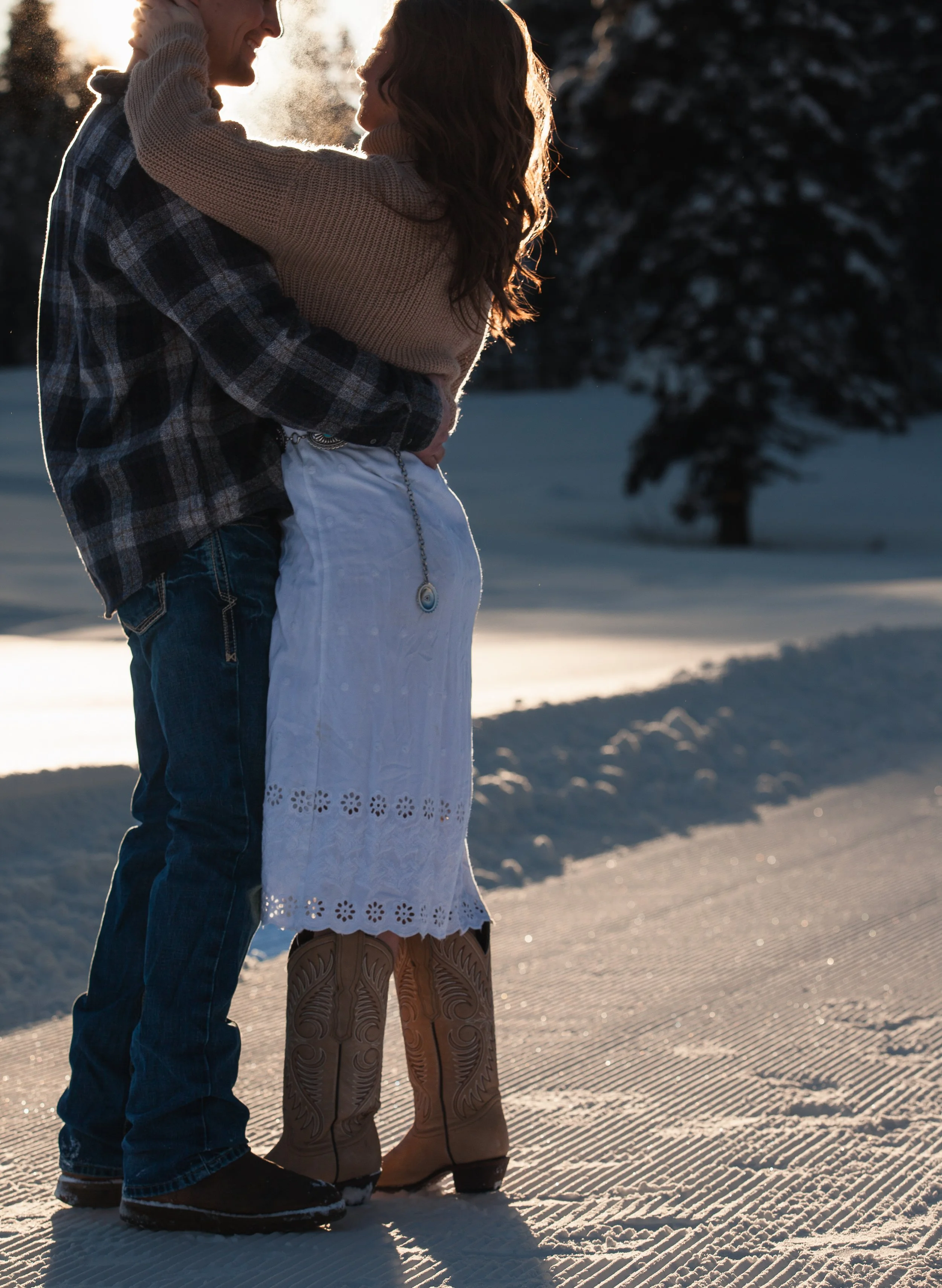 Engaged couple embracing in the snow during a winter engagement session near McCall, Idaho.