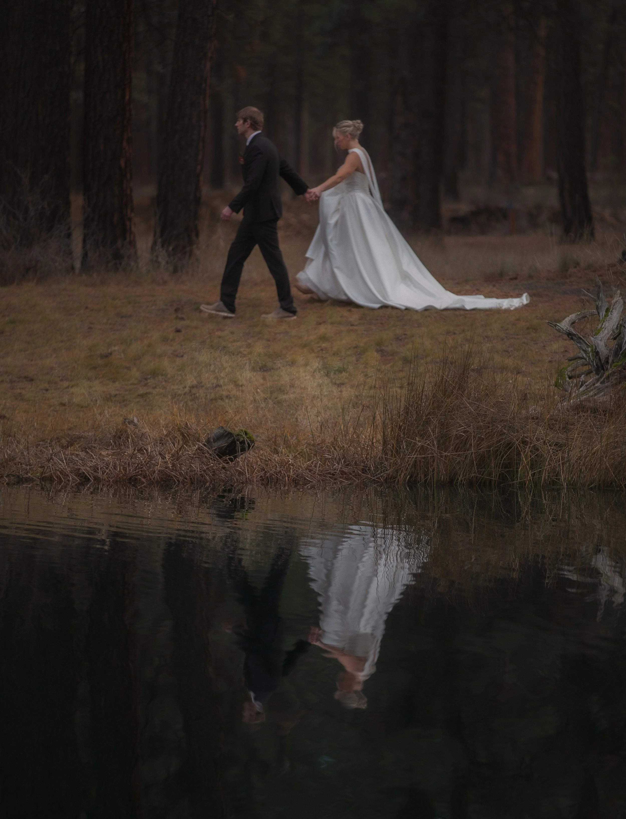 Bride and groom reflected in a quiet forest lake during an editorial wedding shoot in Camp Sherman.