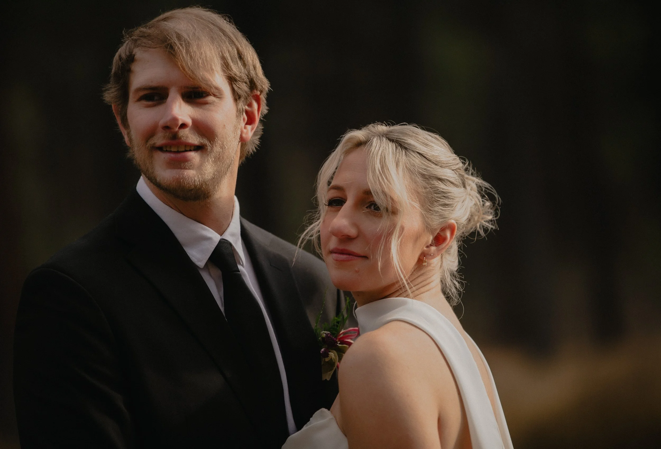 Editorial wedding portrait of a bride and groom beside a forest lake in Camp Sherman, Oregon.