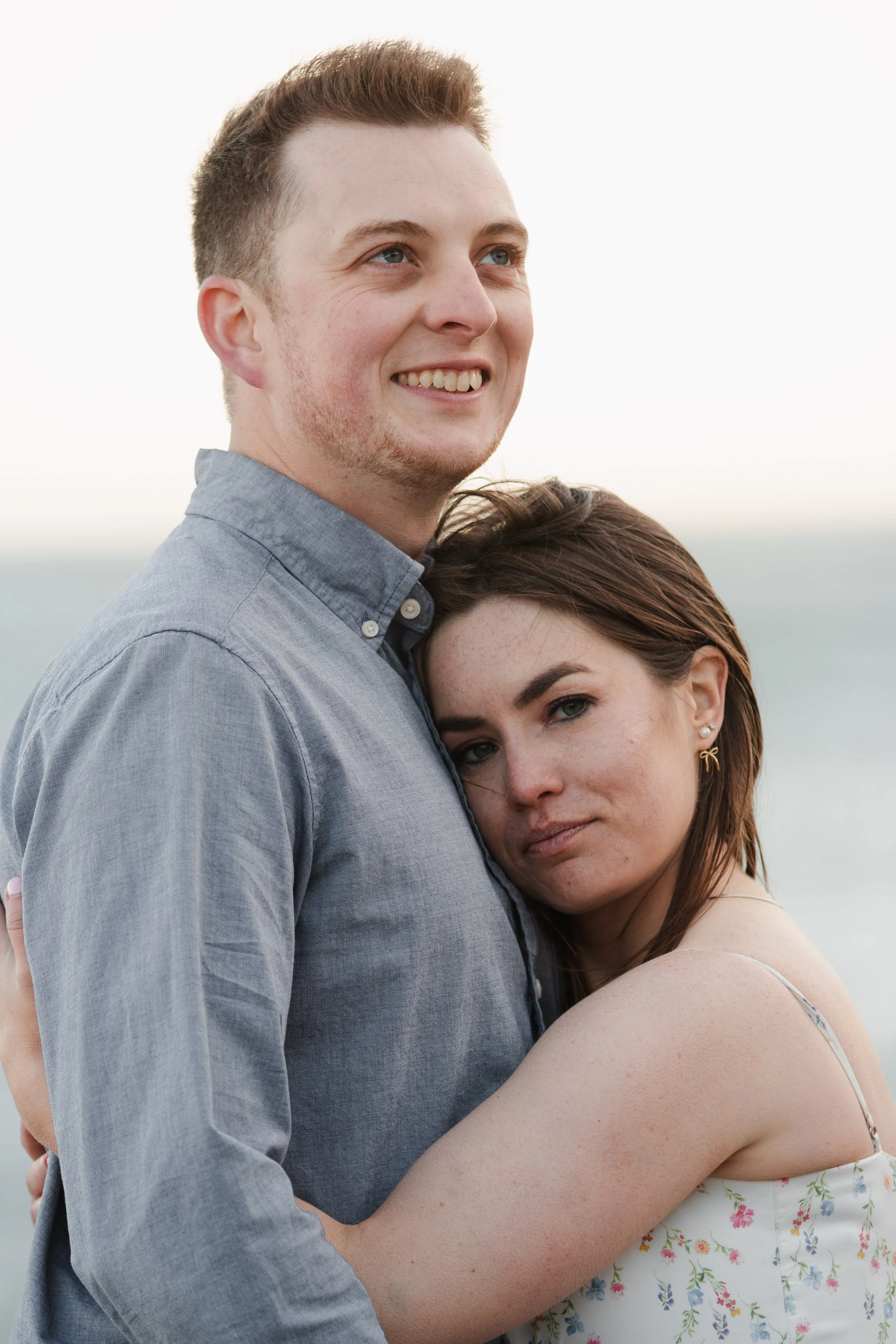 Bride and groom embracing beside the ocean during golden hour engagement photos on the Oregon Coast.