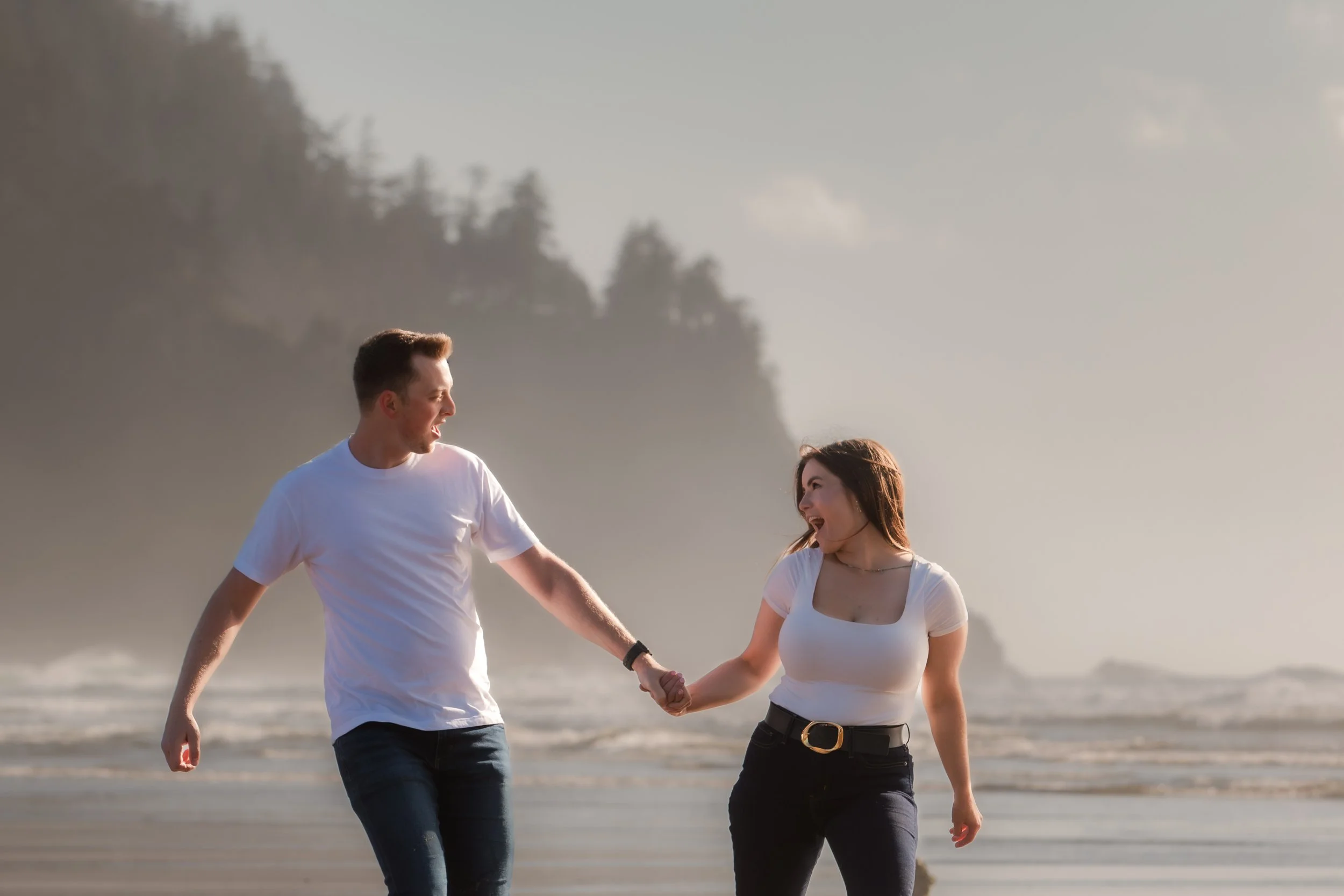Bride and groom walking hand in hand along the beach during their Pacific City engagement session.