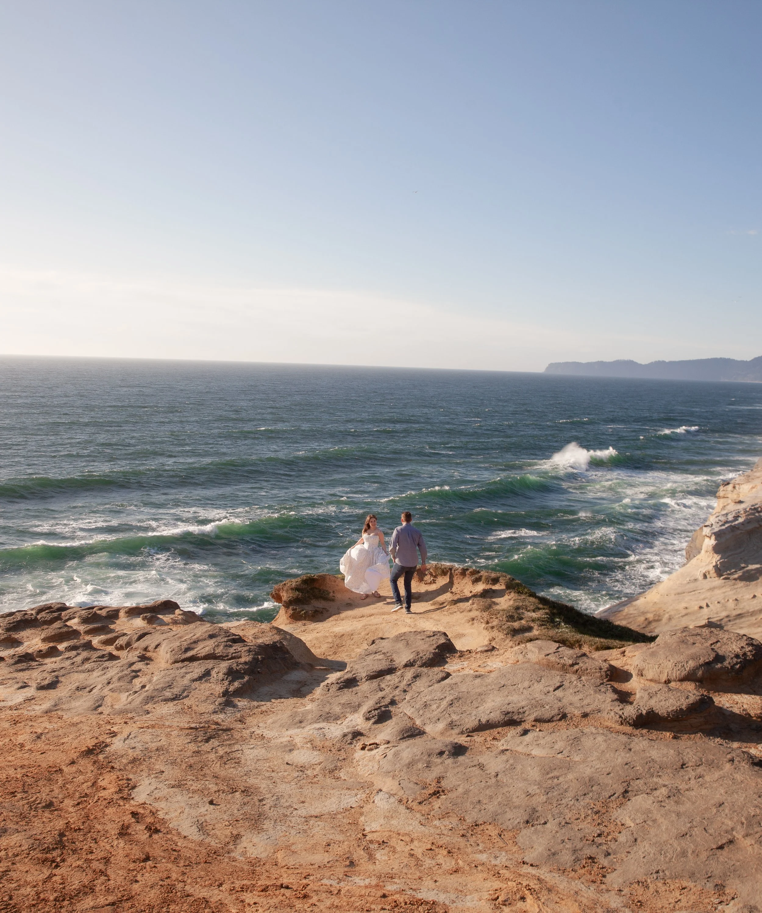 Wide coastal engagement portrait overlooking the Pacific Ocean near Pacific City, Oregon.