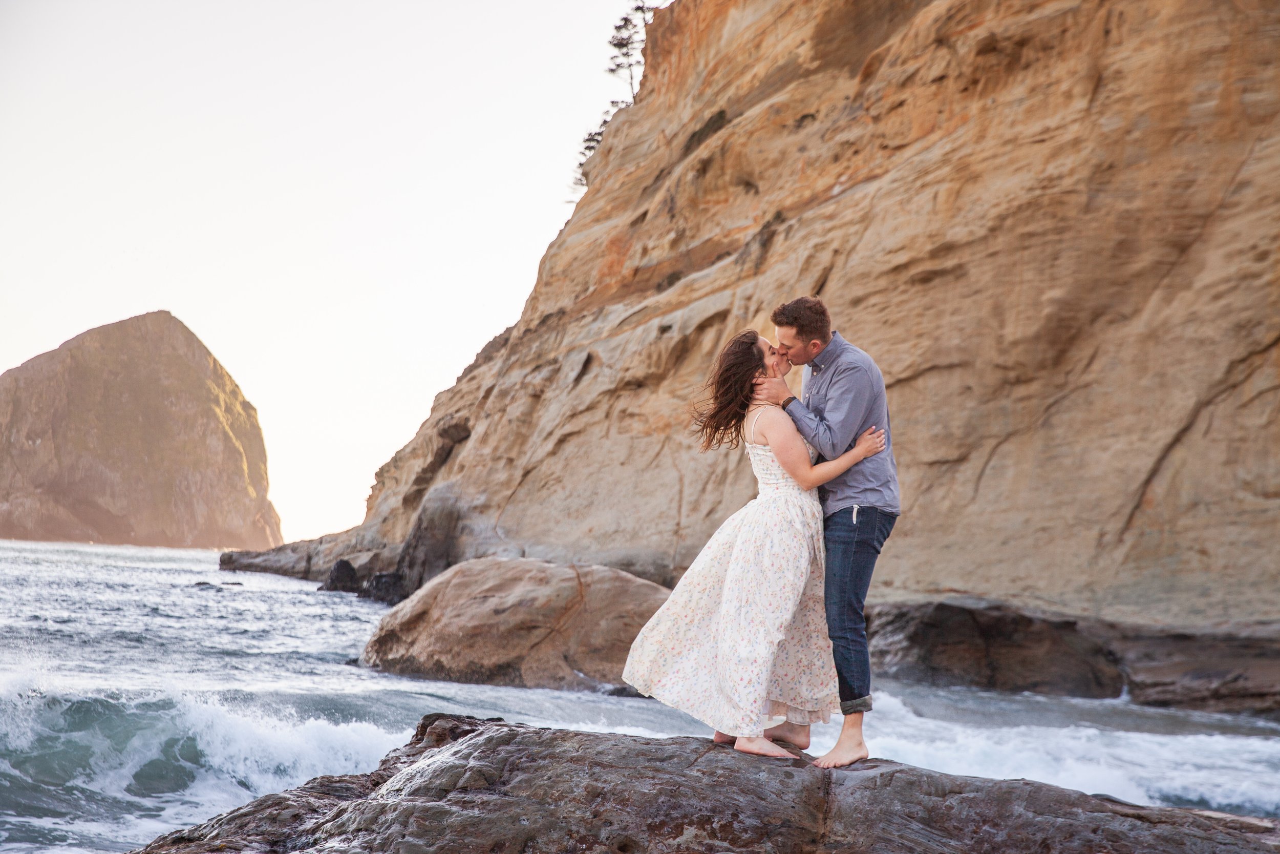 Romantic engagement portrait beside the cliffs at Cape Kiwanda in Pacific City, Oregon.