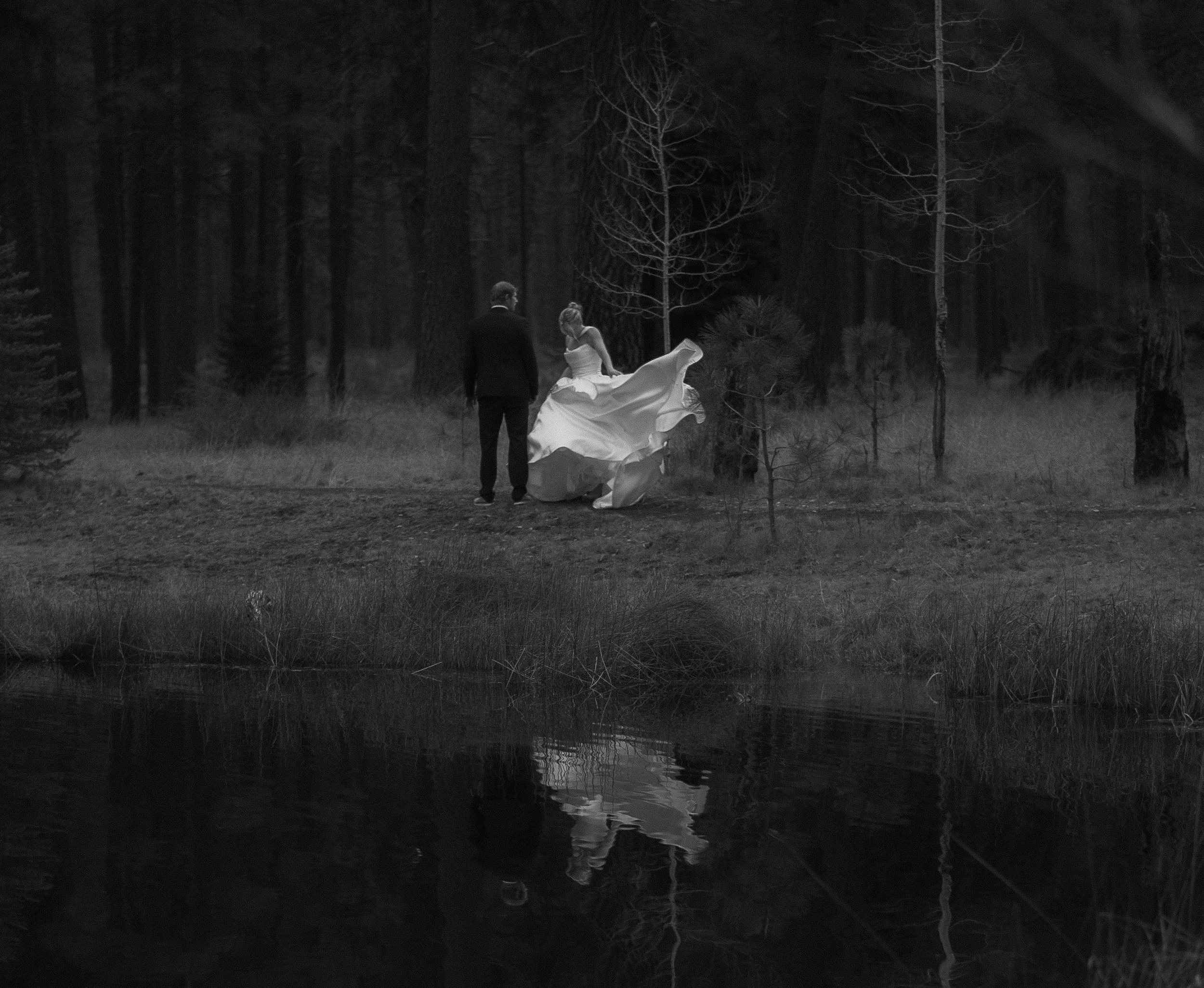 Bride and groom reflected in a quiet forest lake during an editorial wedding shoot in Camp Sherman.