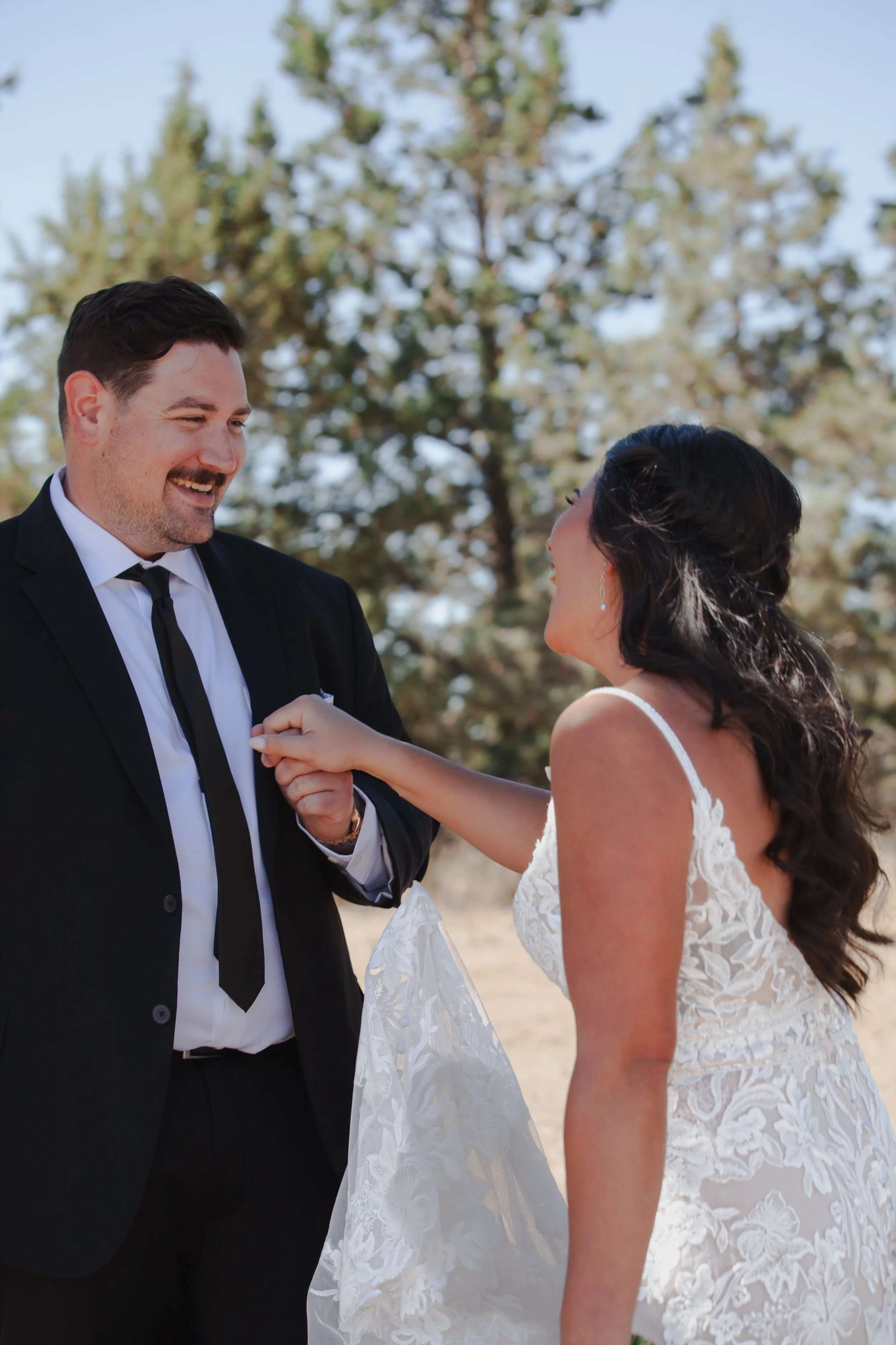 Bride and groom laughing together during their outdoor ranch wedding ceremony near Bend, Oregon.