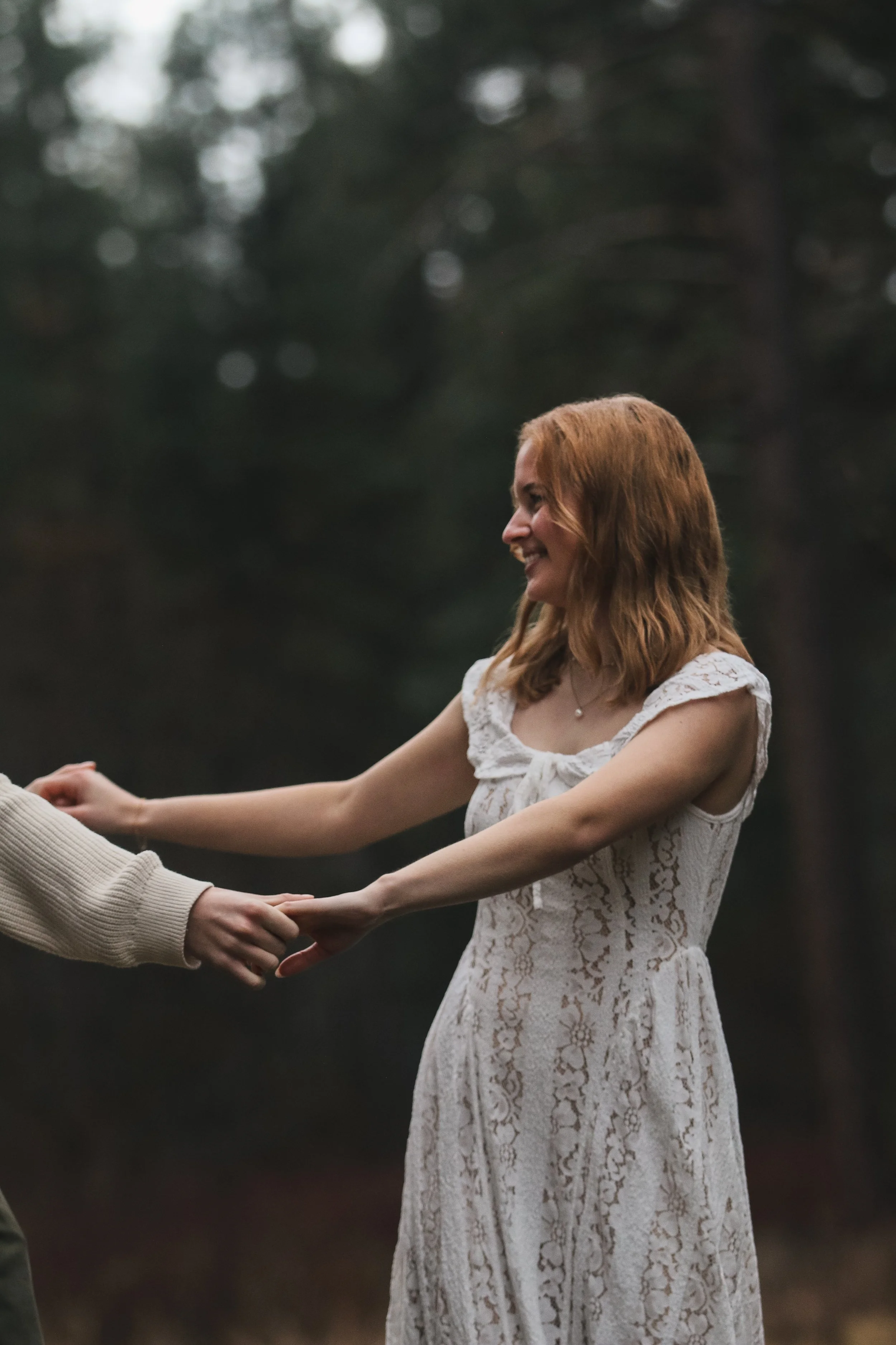 Engaged couple walking hand in hand through the pine forest during a Central Oregon engagement session near Sisters.