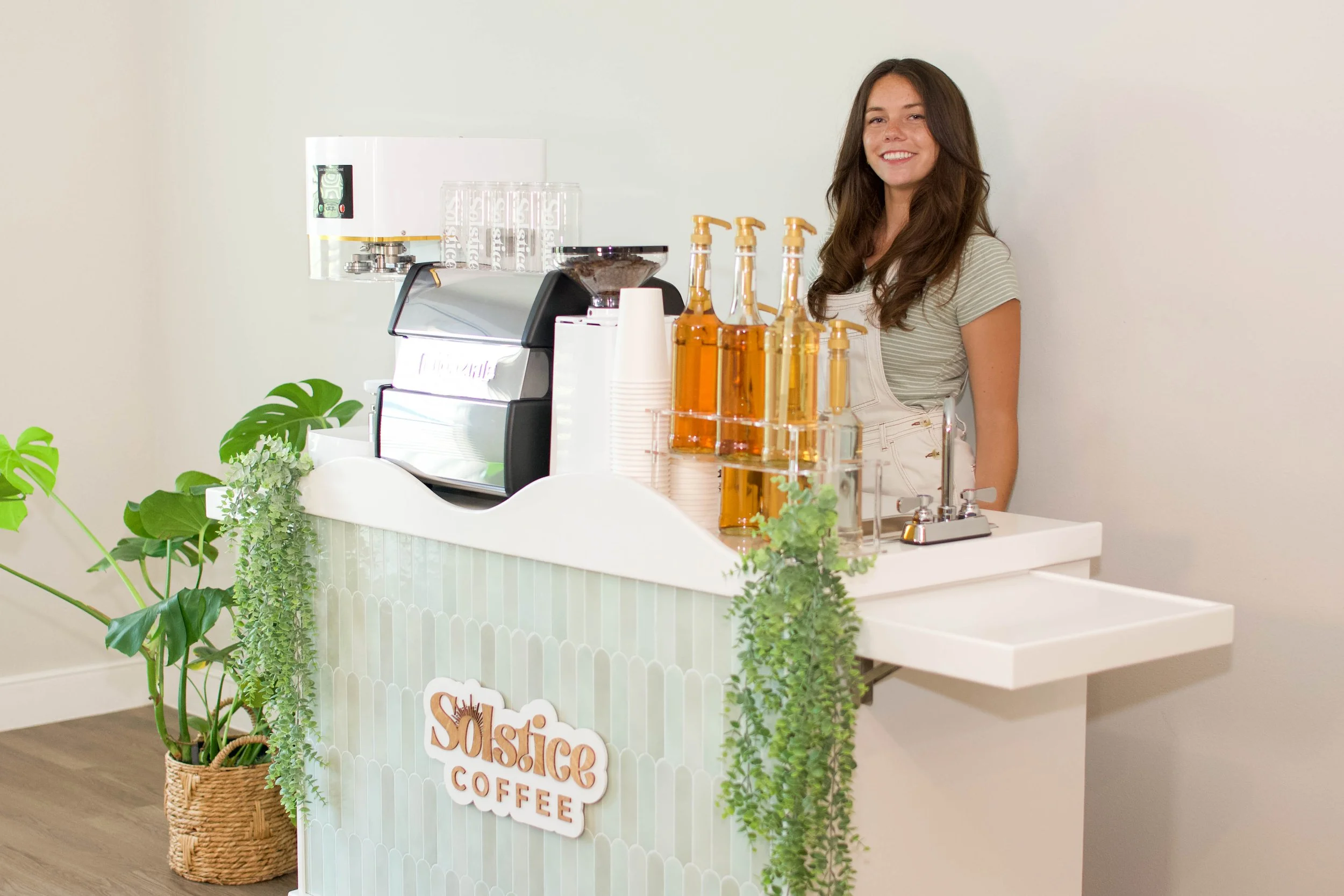 Barista standing behind coffee cart that serves espresso drinks in Austin, texas.