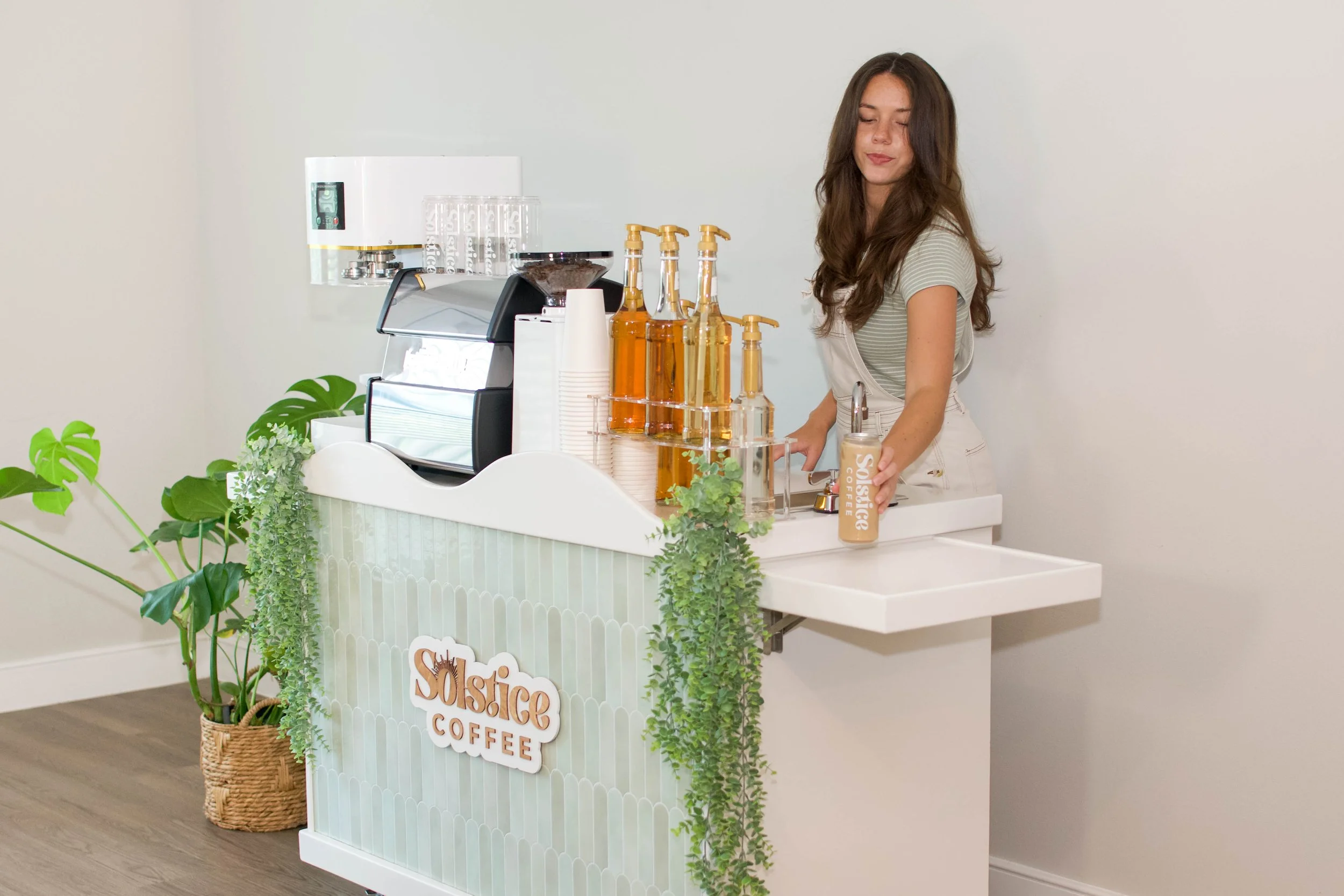 a barista behind a coffee cart serves a canned latte to a customer at a coffee cart event in Austin texas.