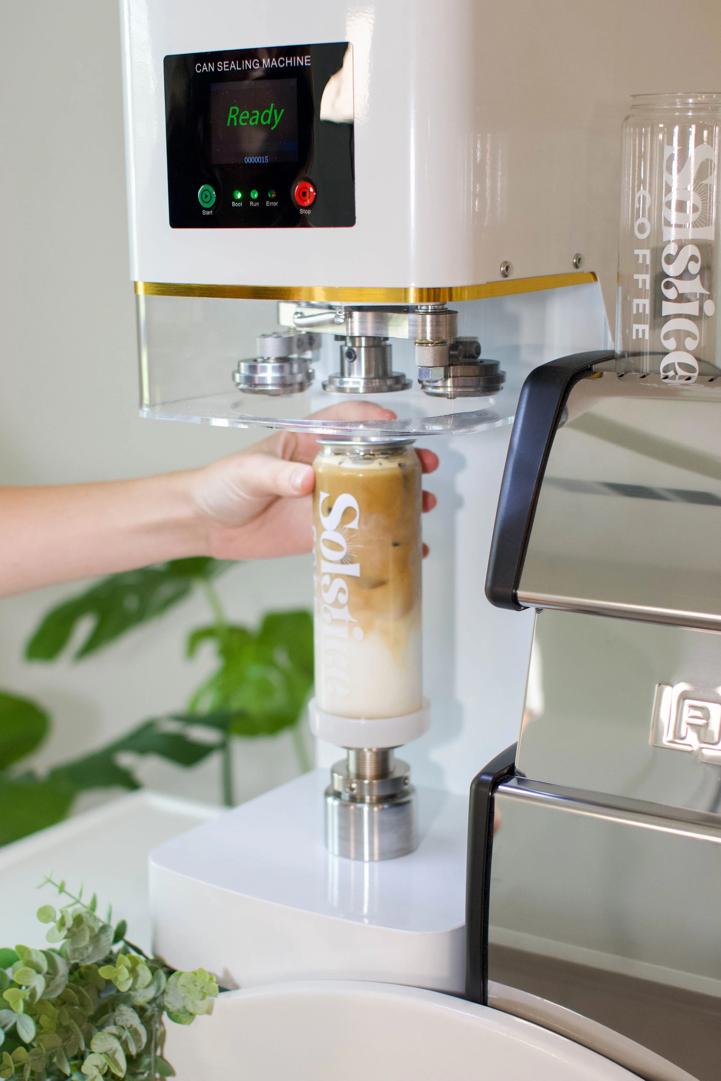 Shows the canning machine being used to seal canned lattes for solstice coffee cart.