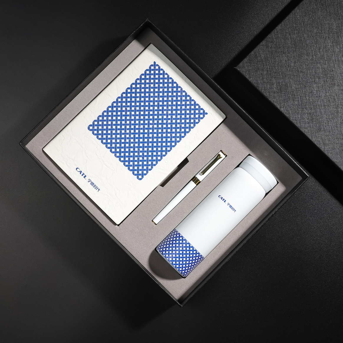Set of stationery items including a patterned notepad, a pen, and a thermos in a gift box