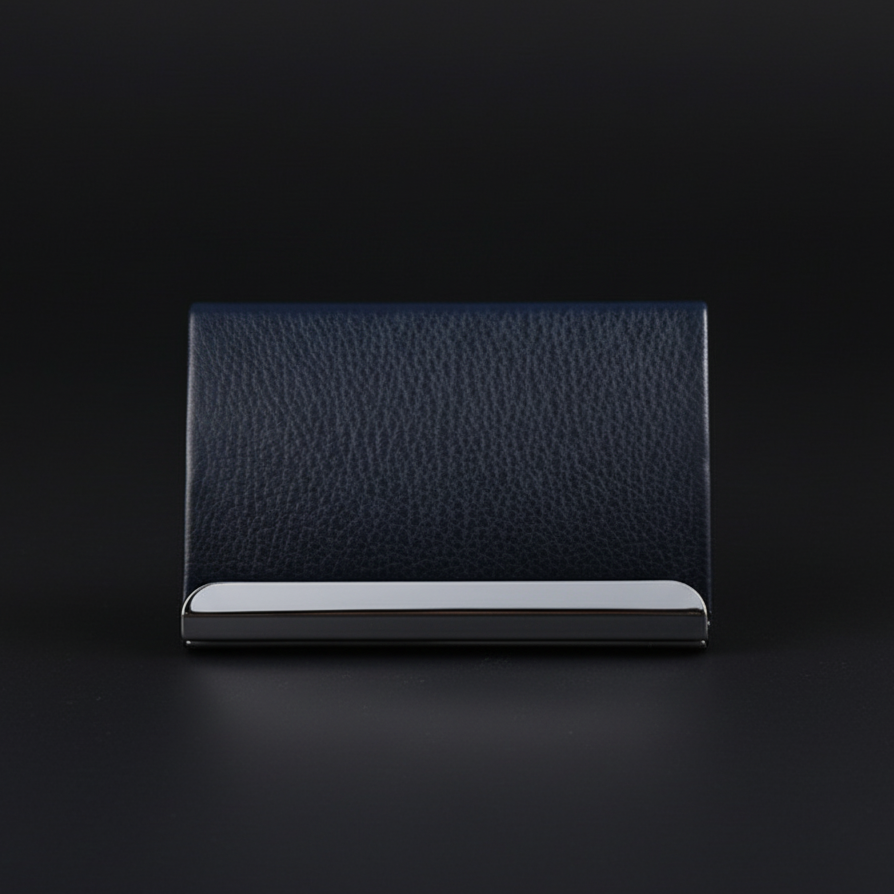 A black wallet made of textured leather with a silver accent, placed on a dark surface against a black background.