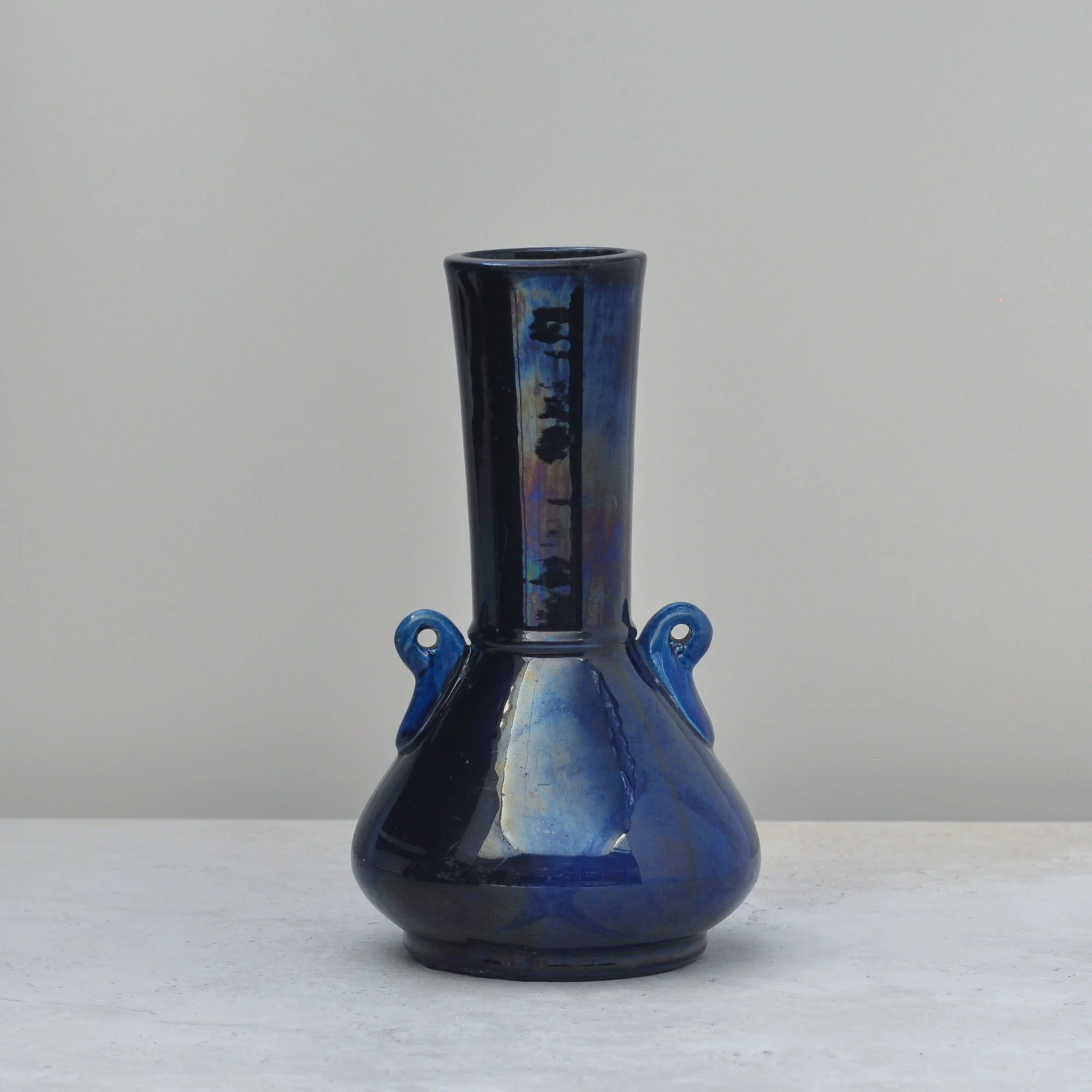 Japanese art pottery vase with deep iridescent blue drip glaze and elegant curved form