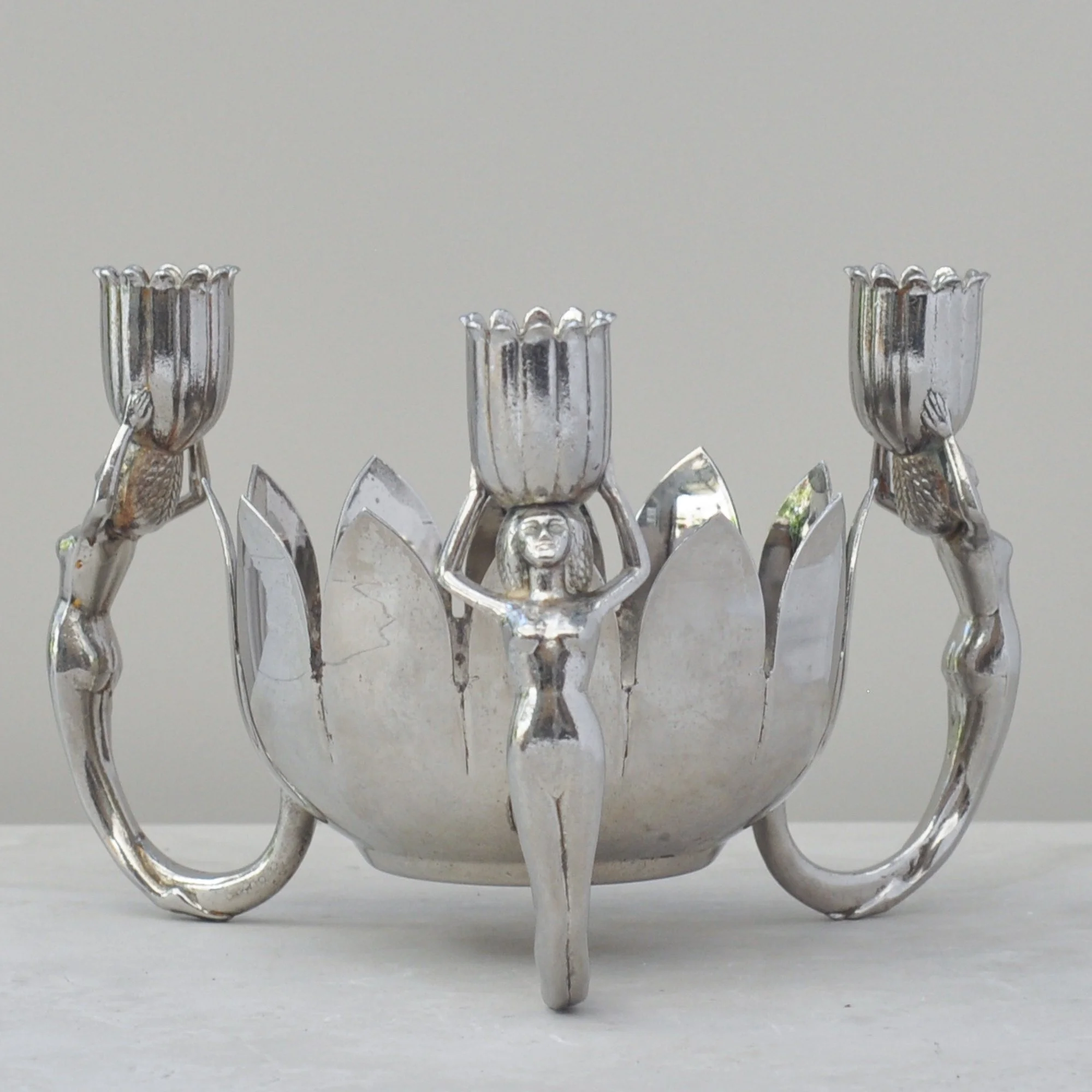 Close-up of the sculptural female figure supporting a tulip-form candle holder.