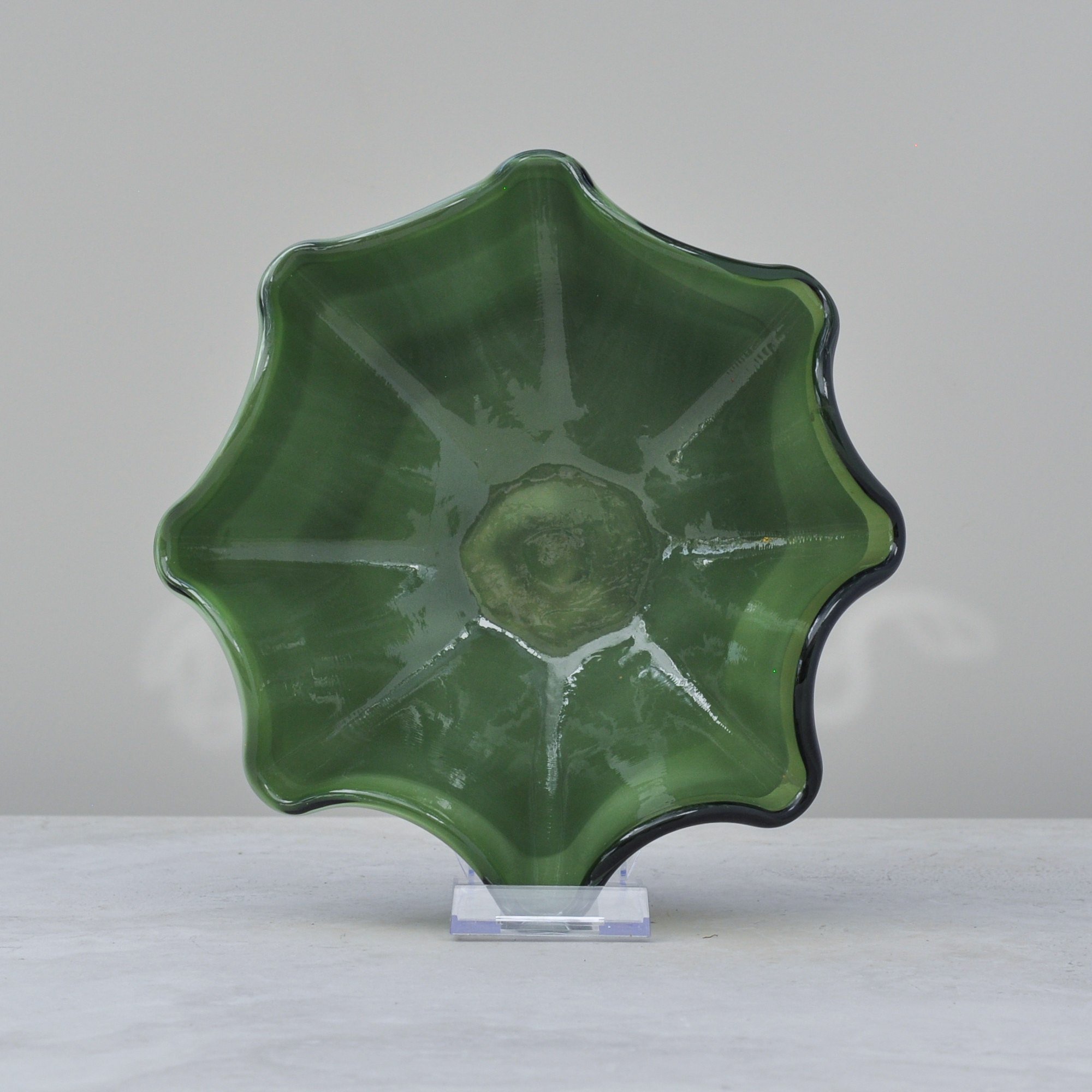 Top-down view of handblown olive green glass bowl showing organic wave shape.