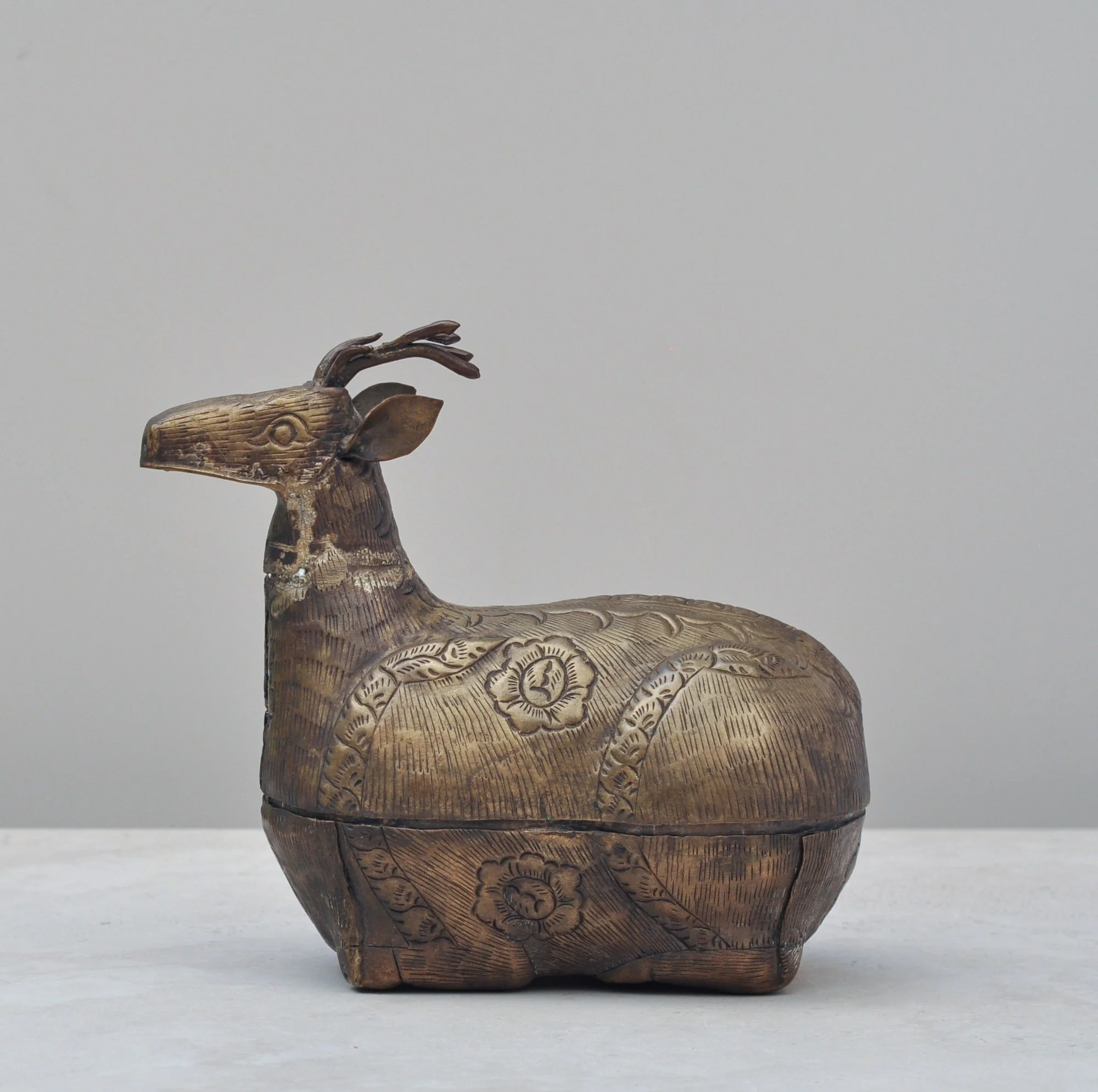 Vintage brass deer-shaped lidded box with engraved detailing, front view.