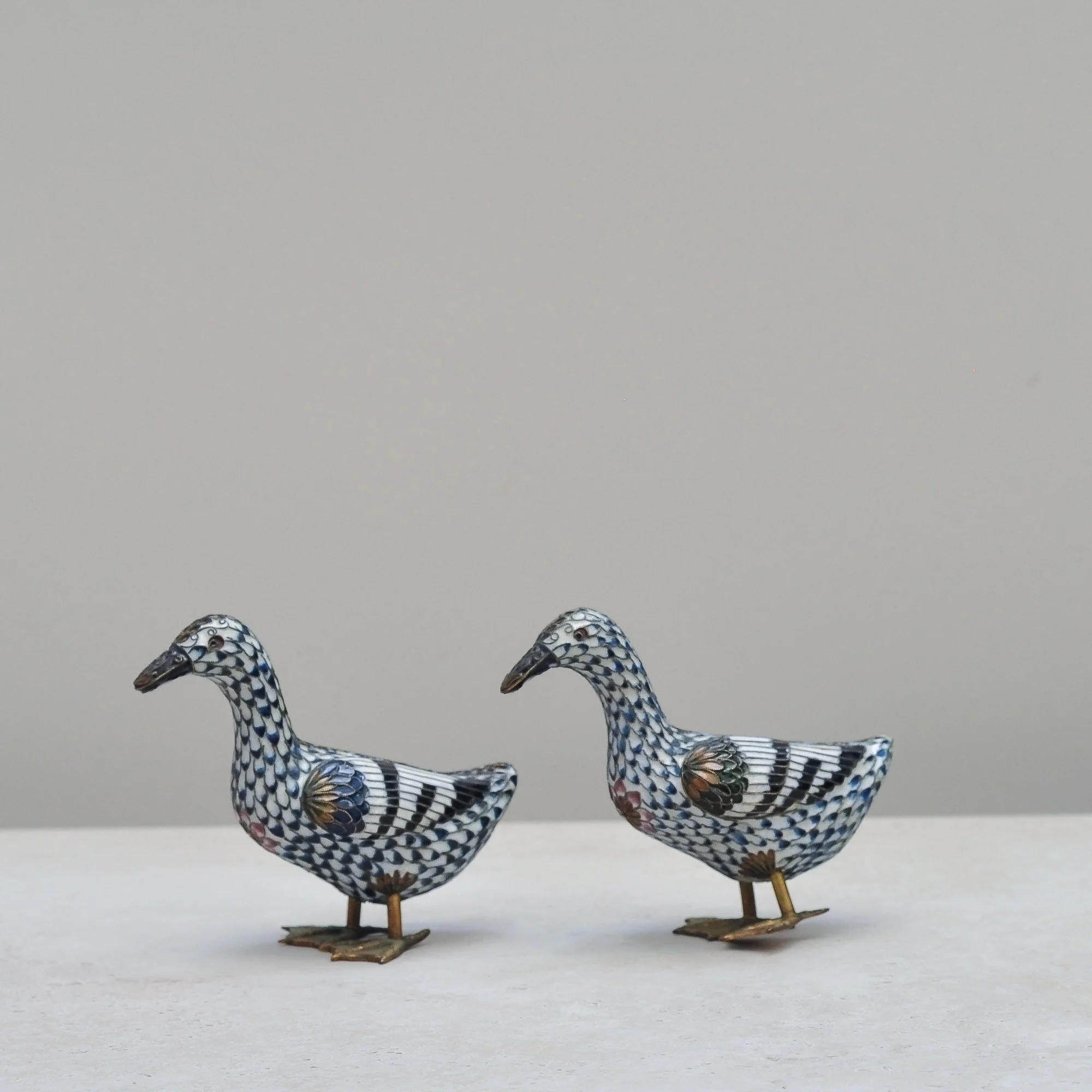 Brass cloisonné duck figurines showing detailed hand-enamelled wings.