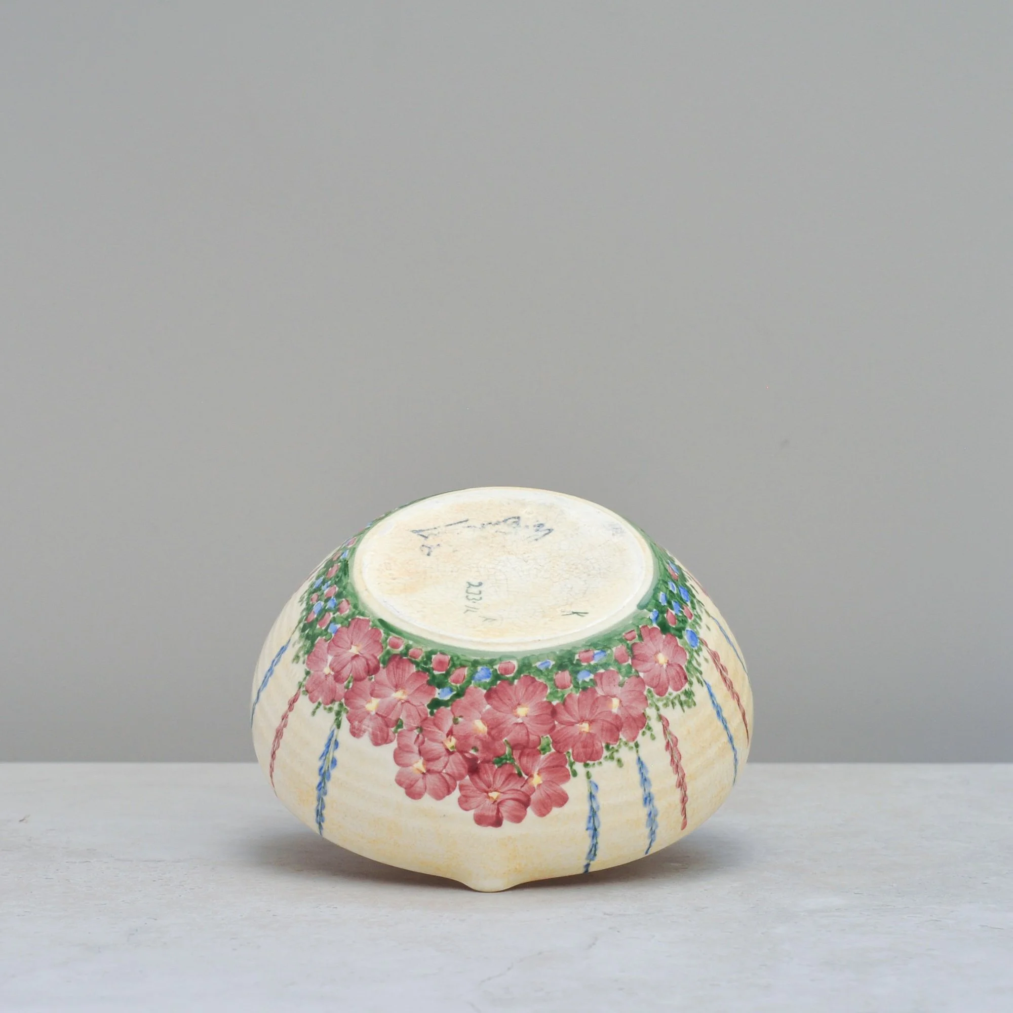 Base of an Art Deco E. Radford ceramic mixing bowl showing hand-painted floral design and maker’s stamp area.