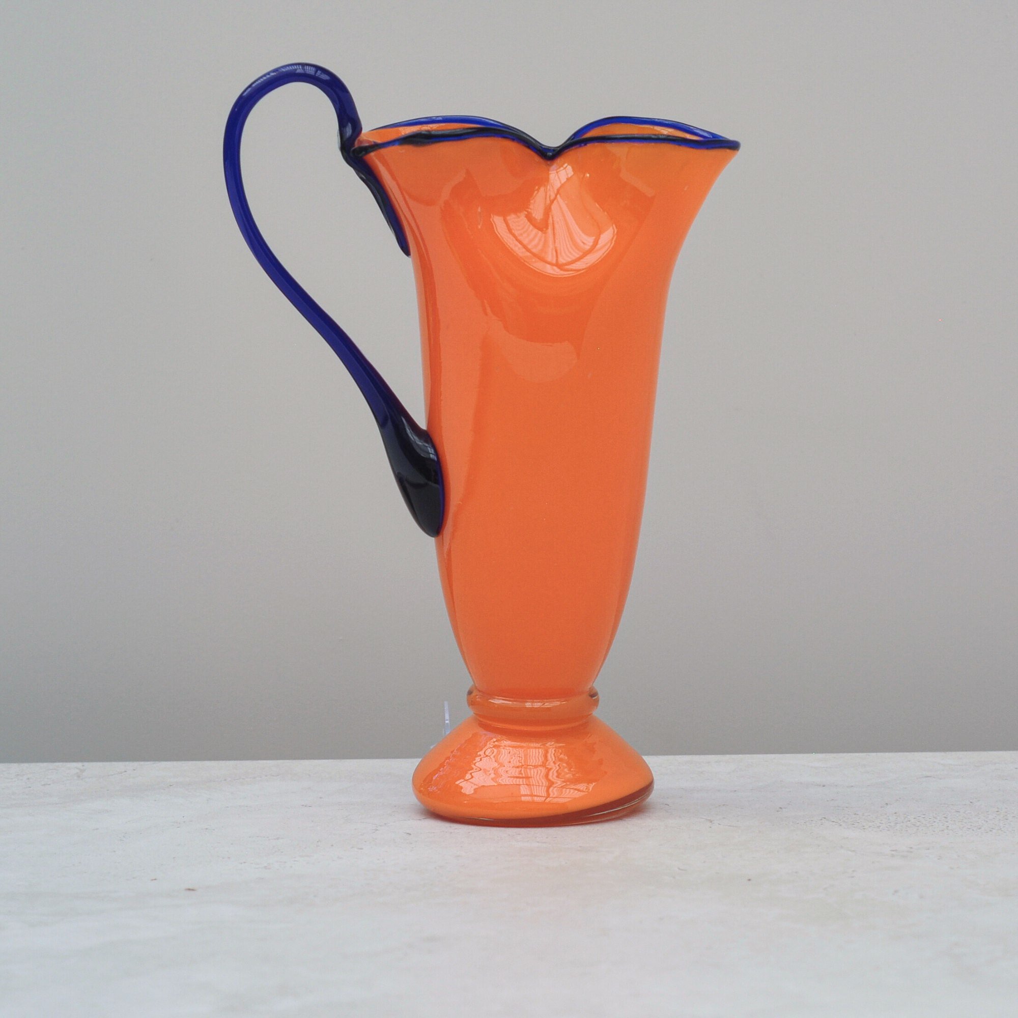 ide view of orange and cobalt Art Deco Tango Glass jug showing applied cobalt handle