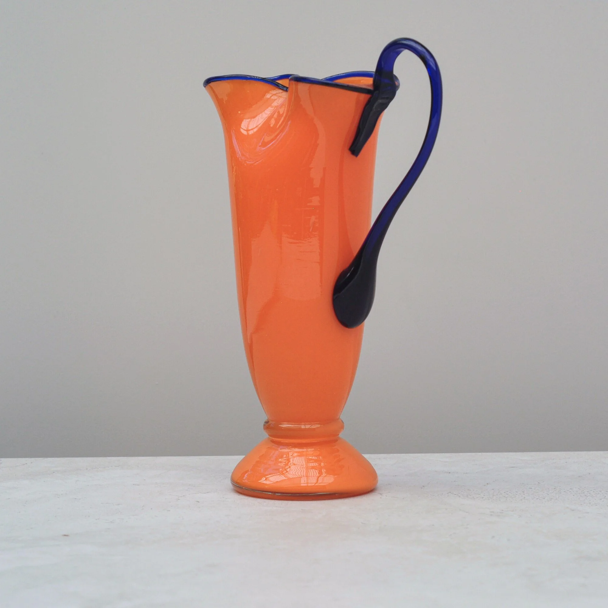 Art Deco Tango Glass jug in orange with cobalt handle, sculptural side profile