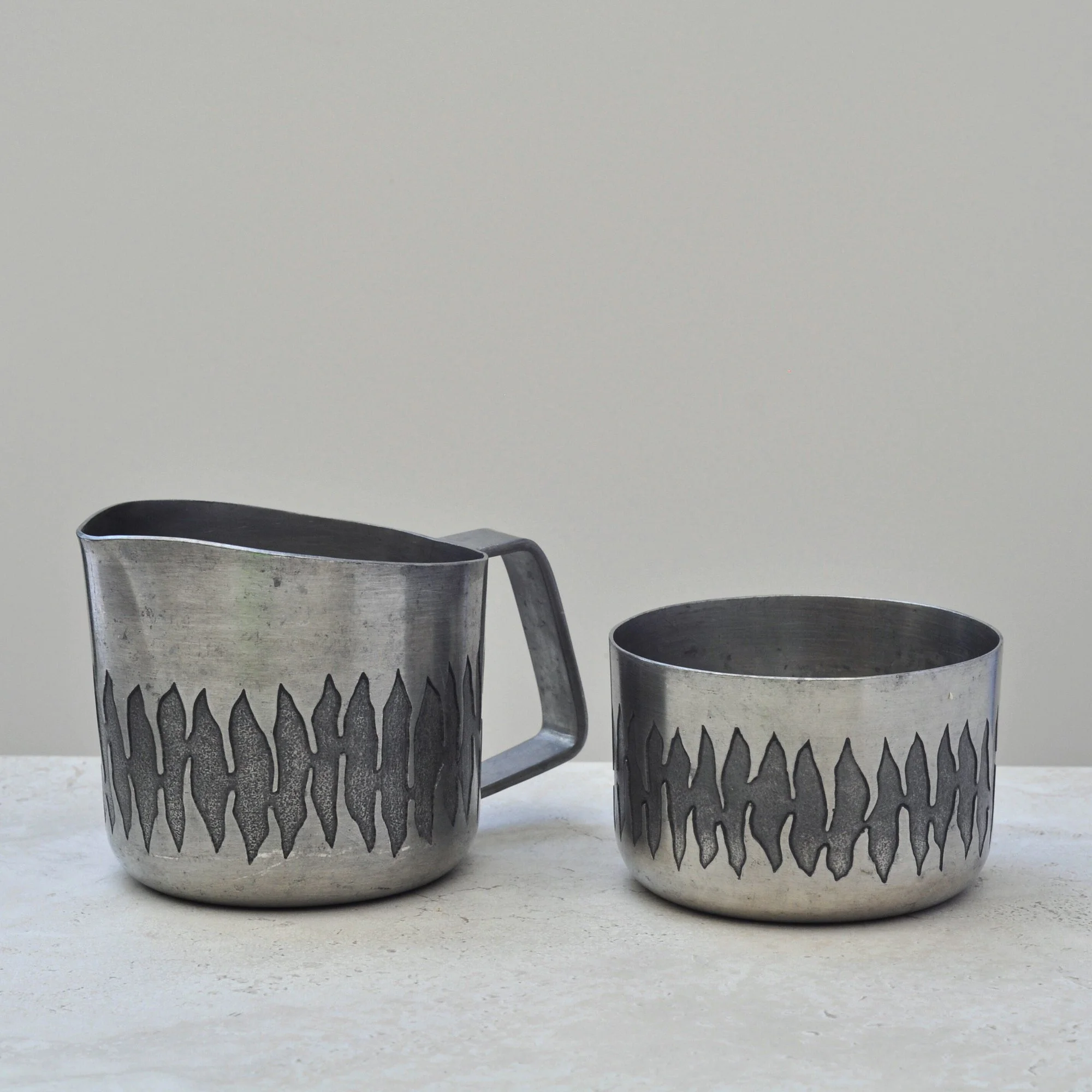 Front view of vintage engraved pewter bowl and matching jug from the June Calcutta set, highlighting the signature wavy etched pattern.