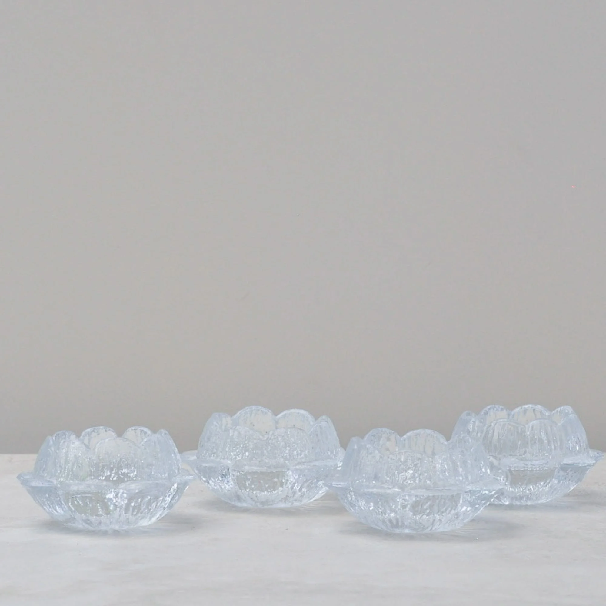 Seven Holmegaard Akande lotus glass candle holders in assorted sizes, Danish mid-century glass design