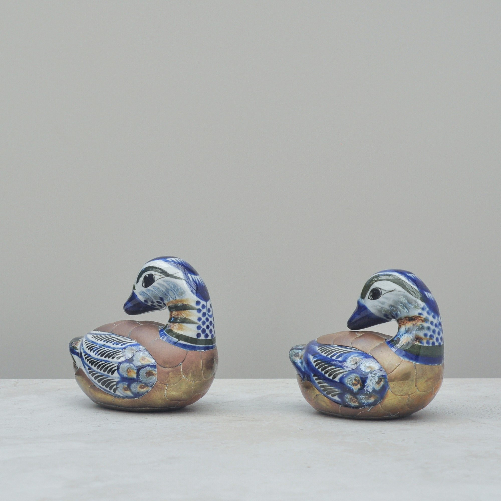 Vintage Tonalá ceramic ducks from Mexico, hand-painted in blue and tan, displayed at a slight angle to show detailed plumage.