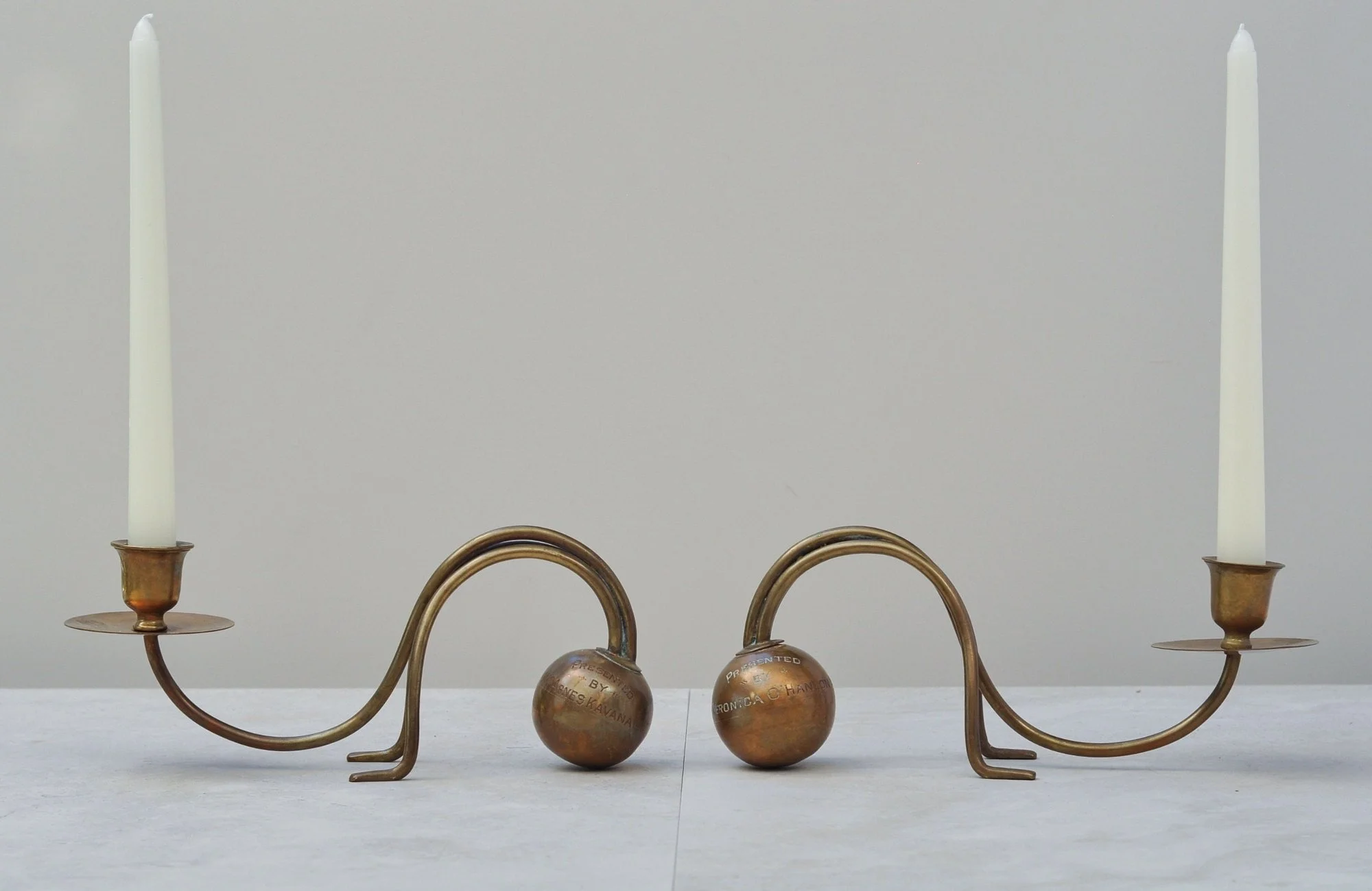 Vintage brass sculptural candlesticks styled with taper candles, neutral background.”