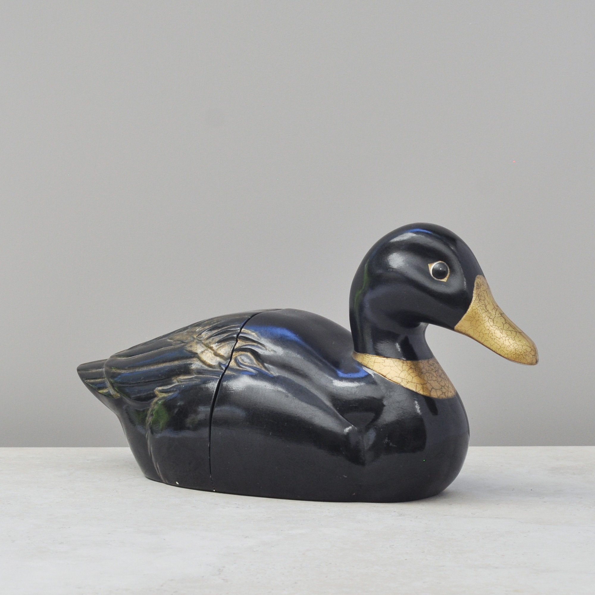 Black and gold ceramic duck bookend front view
