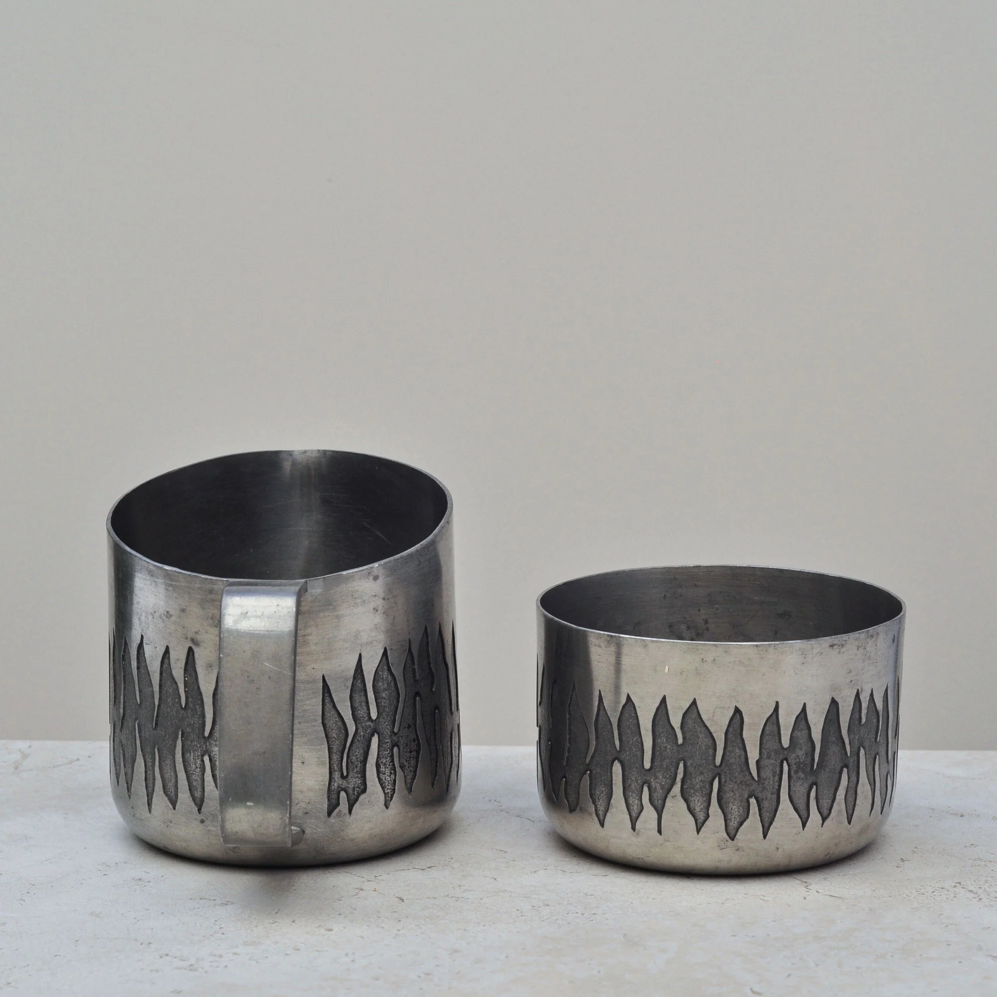 Front view of vintage engraved pewter bowl and matching jug from the June Calcutta set, highlighting the signature wavy etched pattern.