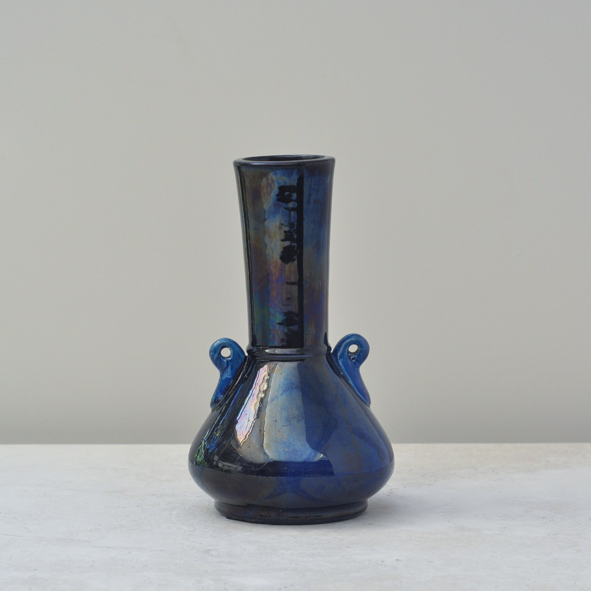 Rear view of Japanese blue art pottery vase with rounded body and slender neck