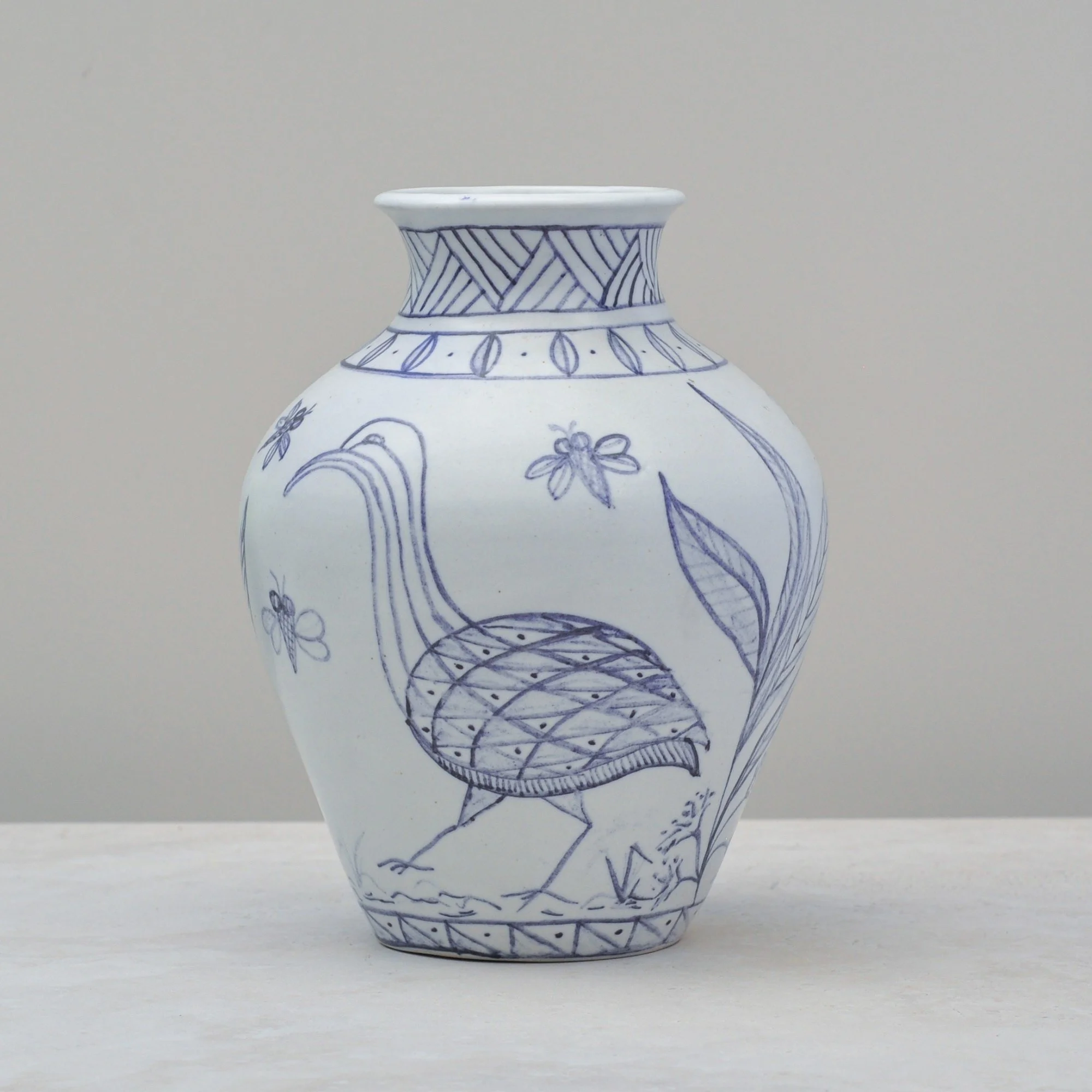 Blue and white ceramic vase viewed from the right angle, showcasing the elongated bird motif and fine linework.