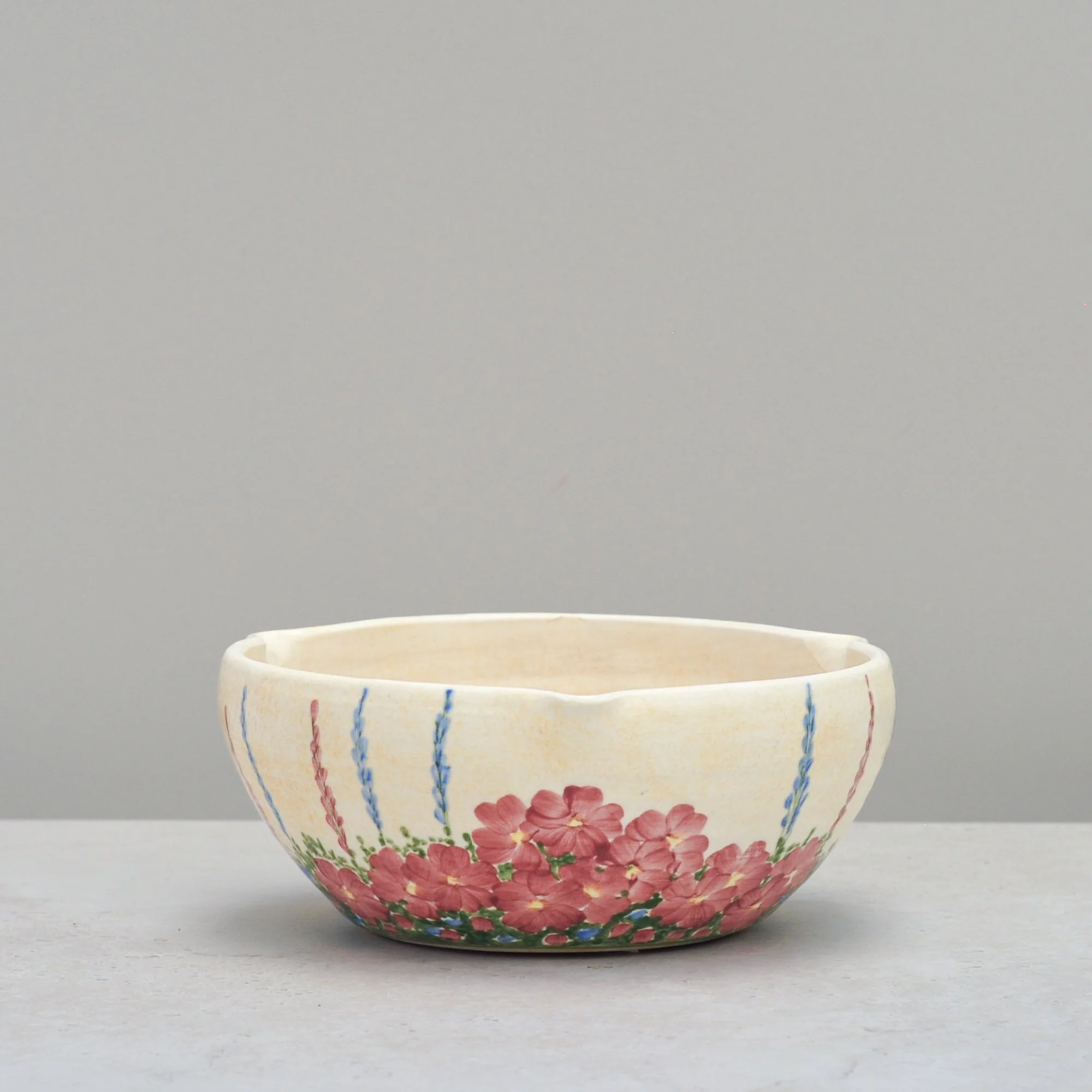 Art Deco E. Radford ceramic mixing bowl with hand-painted florals, shown in an alternate angled front view.