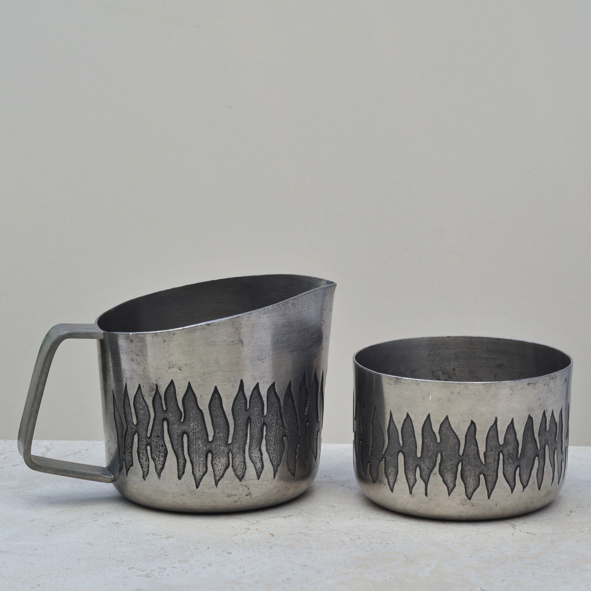 Two-piece Australian pewter set featuring June Calcutta’s engraved jug and matching bowl, shown side by side against a neutral background.