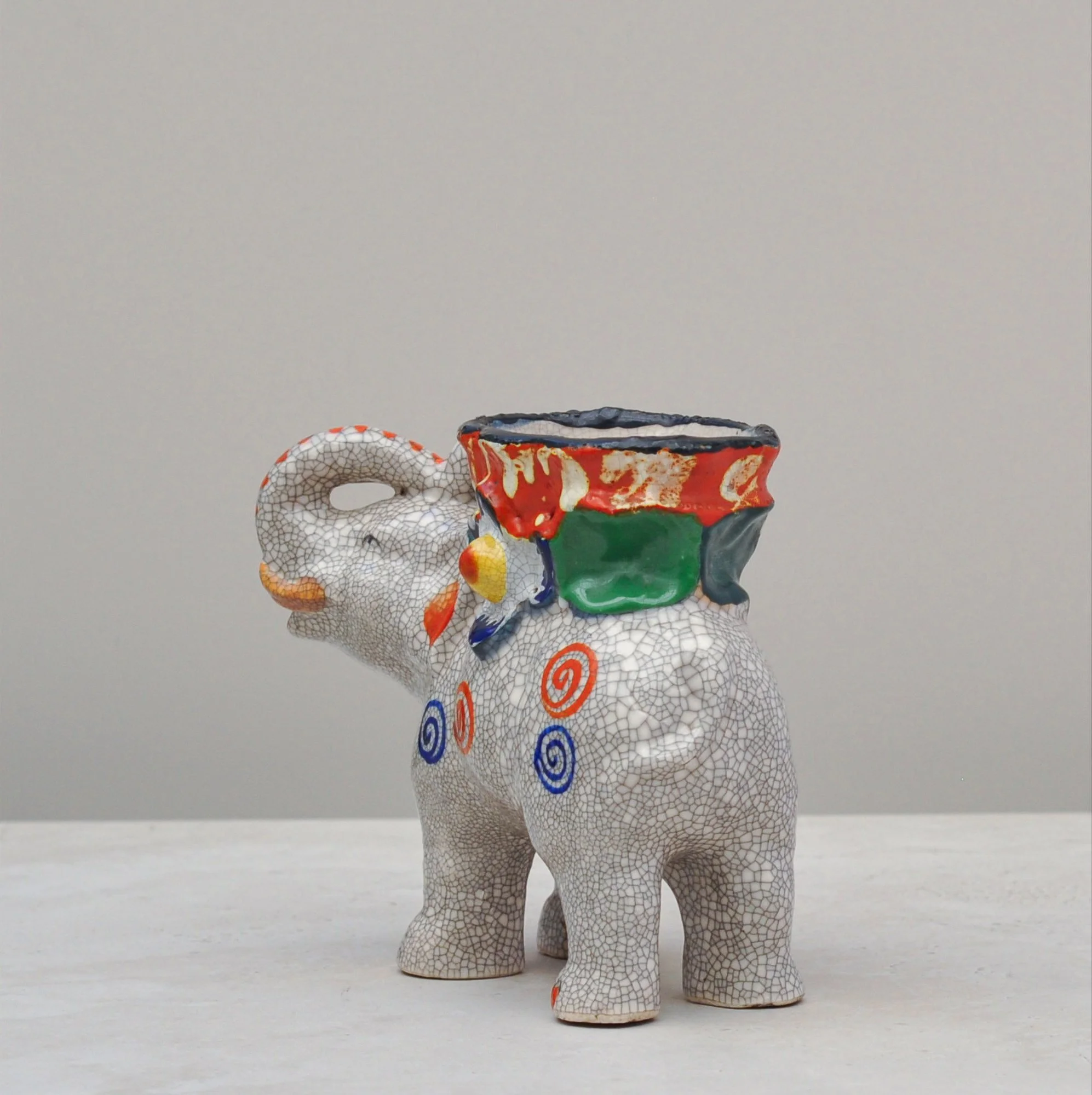 Crackle-glazed elephant vessel viewed from the right side, highlighting its colourful painted detailing.