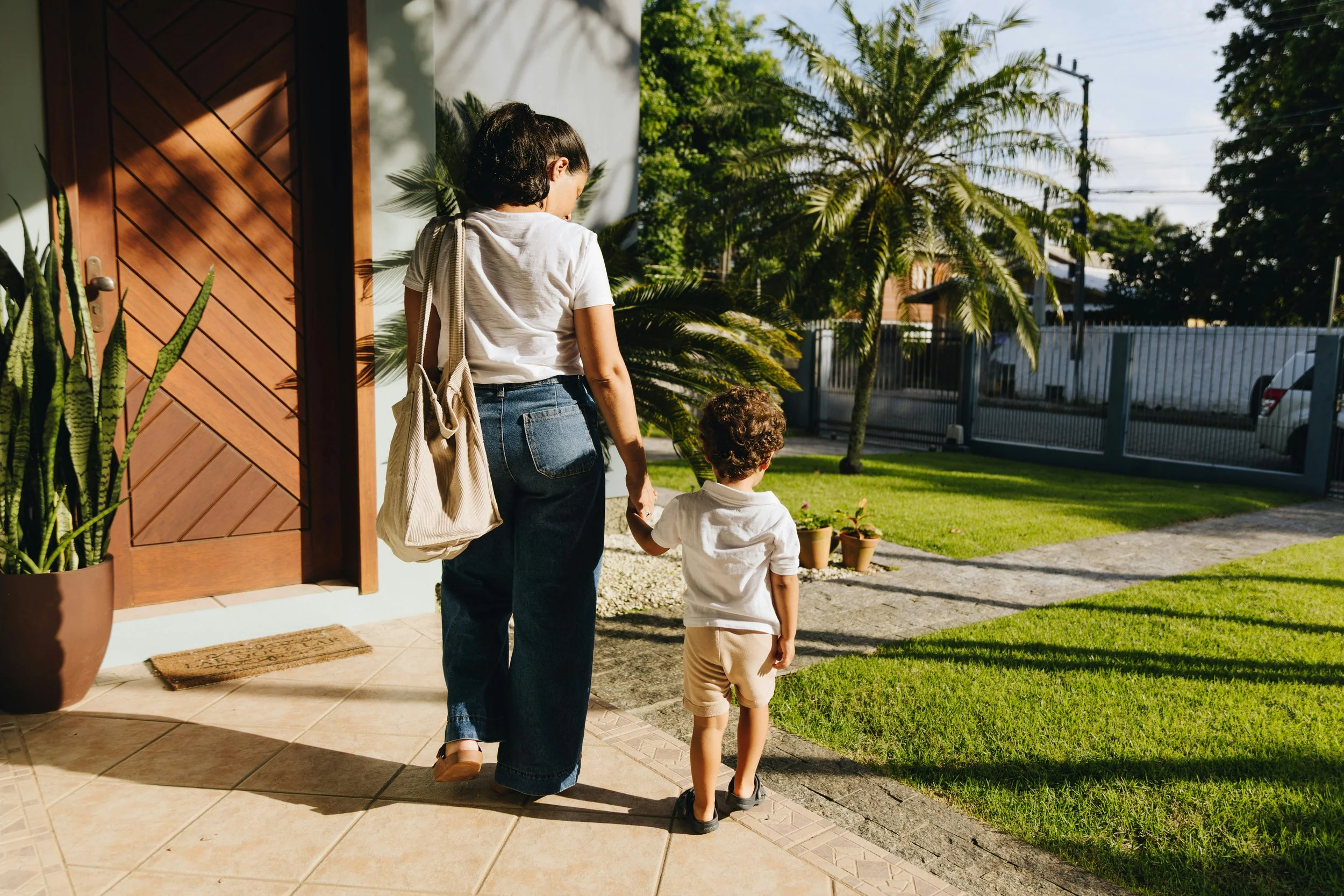 Mom walking with small child towards front door.