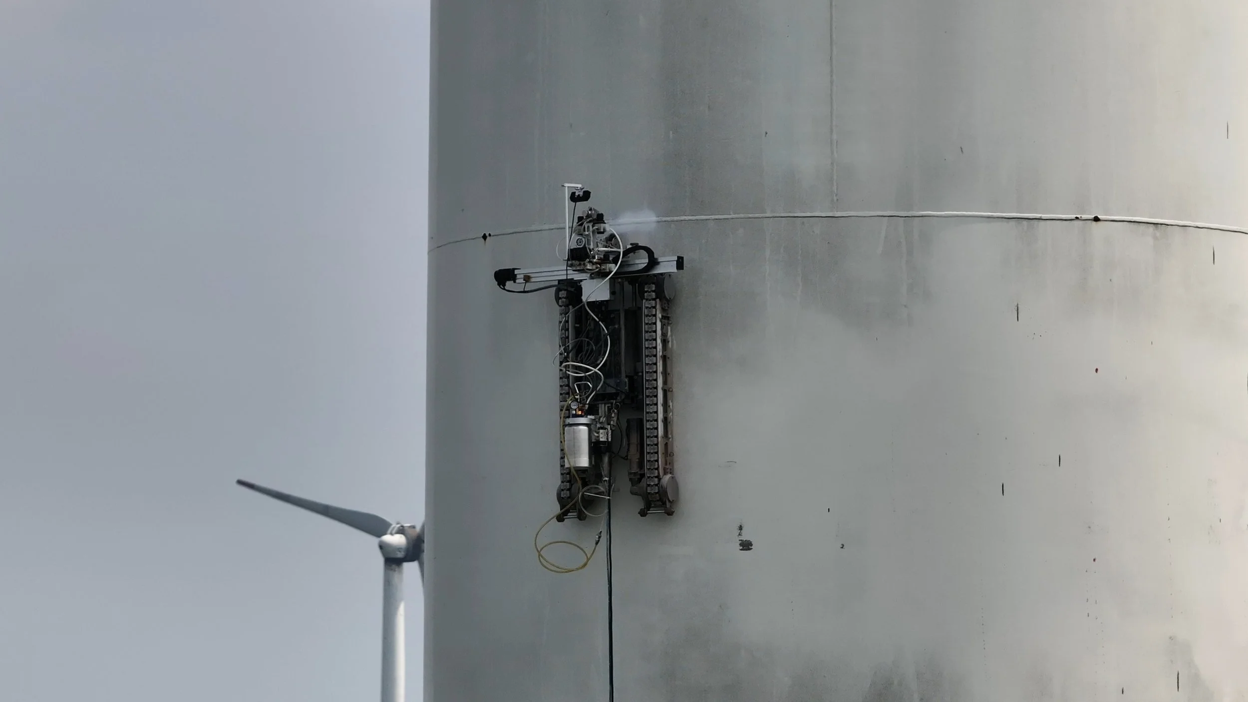 Robotic arm with a yellow and black design operating in smoky environment.