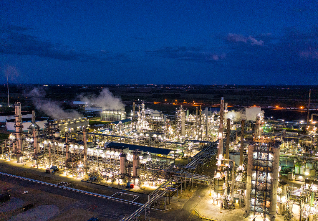 A skydiver in free fall with a parachute deployed above the clouds.