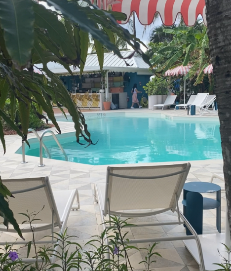 View of the pool at Hampton by Hilton Grand Cayman on Seven Mile Beach with lounge chairs and clear water.