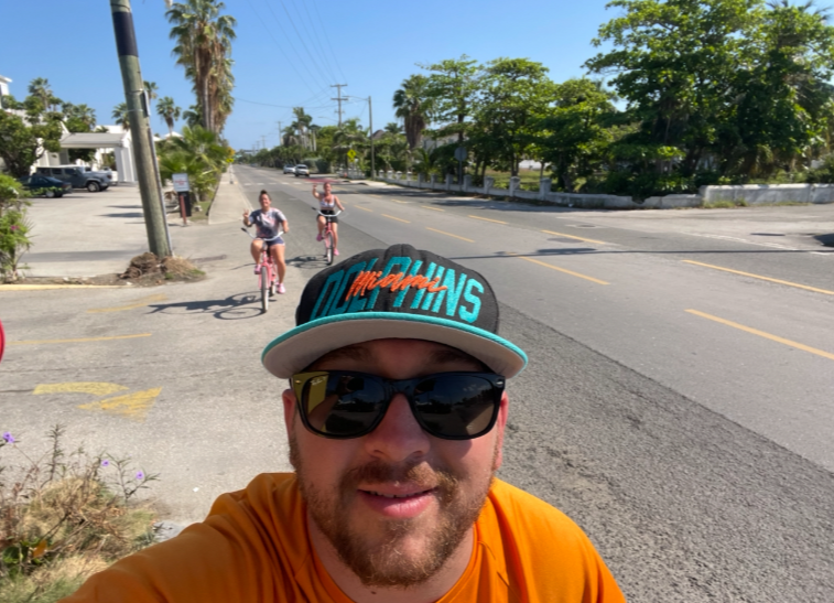 Three people riding bicycles together outdoors on a sunny day.