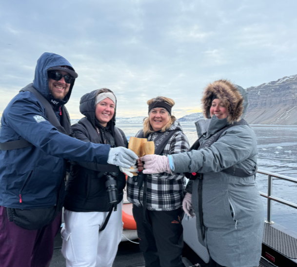 three-women-one-man-cheersing-champagne-arctic-boat.jpg