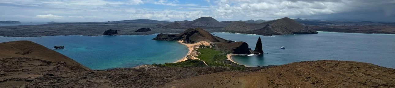 Panoramic view of Bartolomé Island in the Galápagos Islands, showing both sides of the bay and surrounding volcanic landscape.