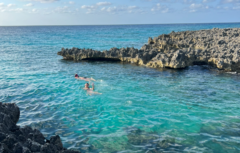 Two girls snorkeling in the clear waters near Macabuca Restaurant, enjoying the marine scenery.