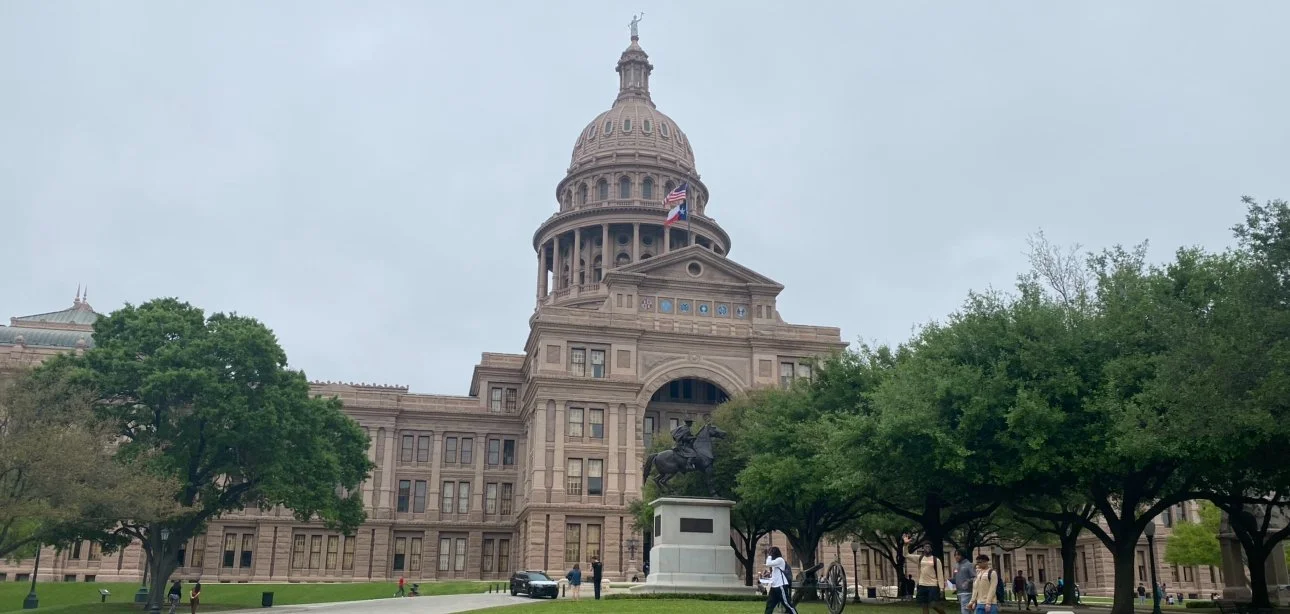 The Texas State Capitol building in Austin, Texas, with its distinctive dome and surrounding grounds.
