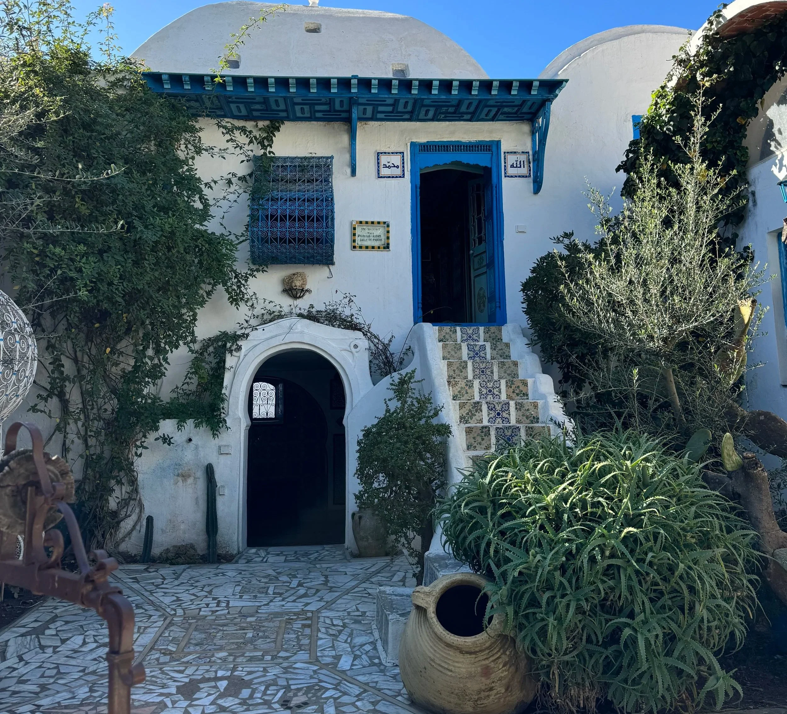A traditional blue and white house in Sidi Bou Said, Tunisia, with vibrant doors, shutters, and Mediterranean-style architecture.
