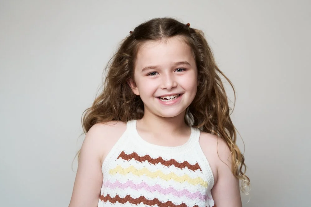 Light-filled childcare portrait in Sydney capturing a genuine smile and playful expression.