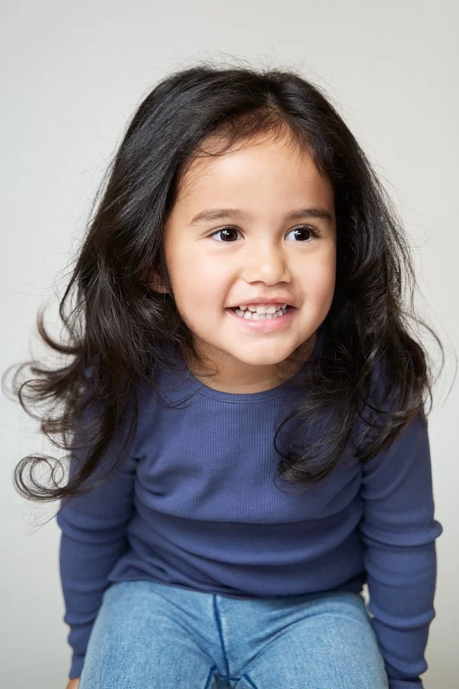 Light-filled childcare portrait in Sydney capturing a genuine smile and playful expression.