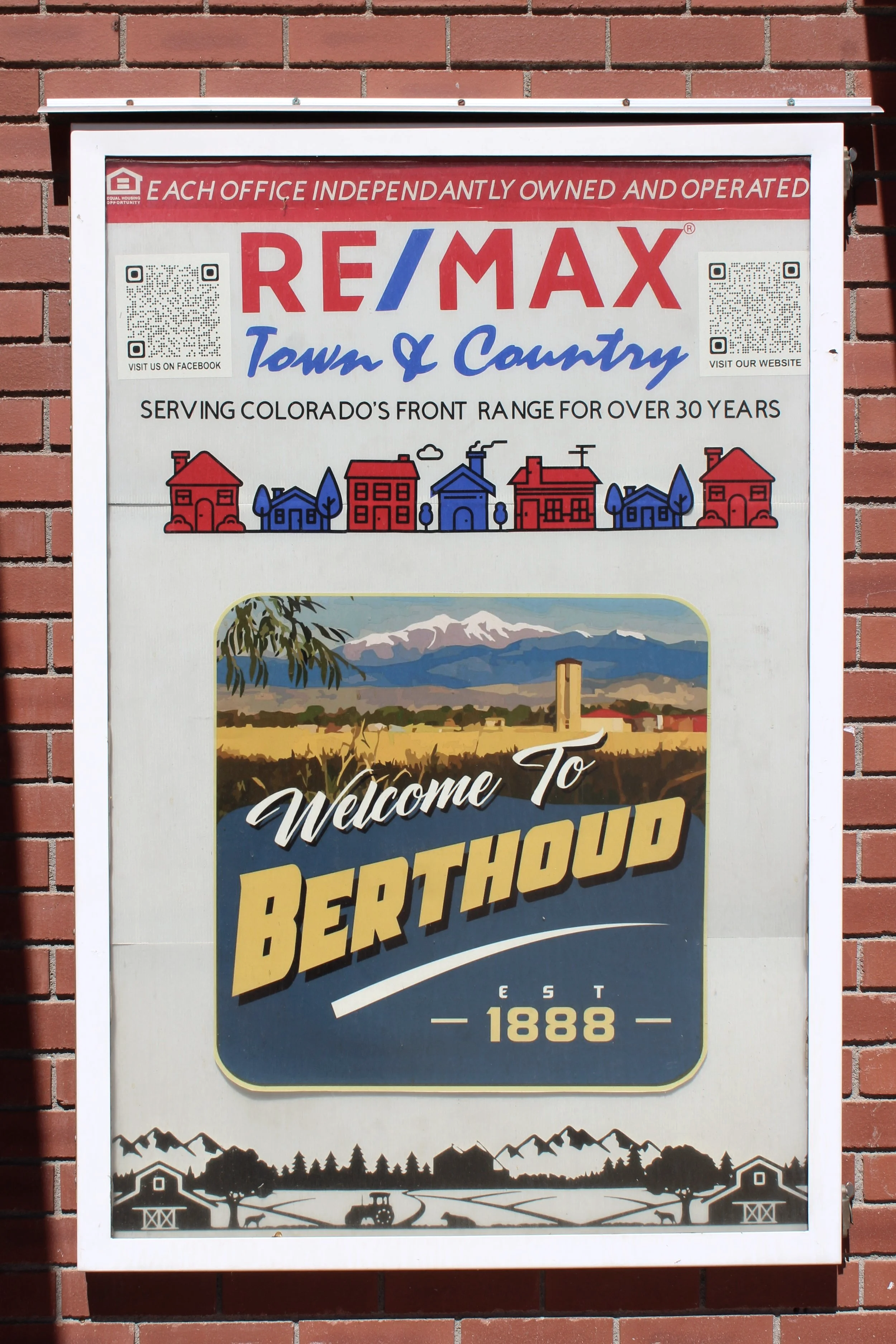 a sign for RE/Max Town and Country appearing on the side of a building along with a sign for the town of Berthoud, Colorado