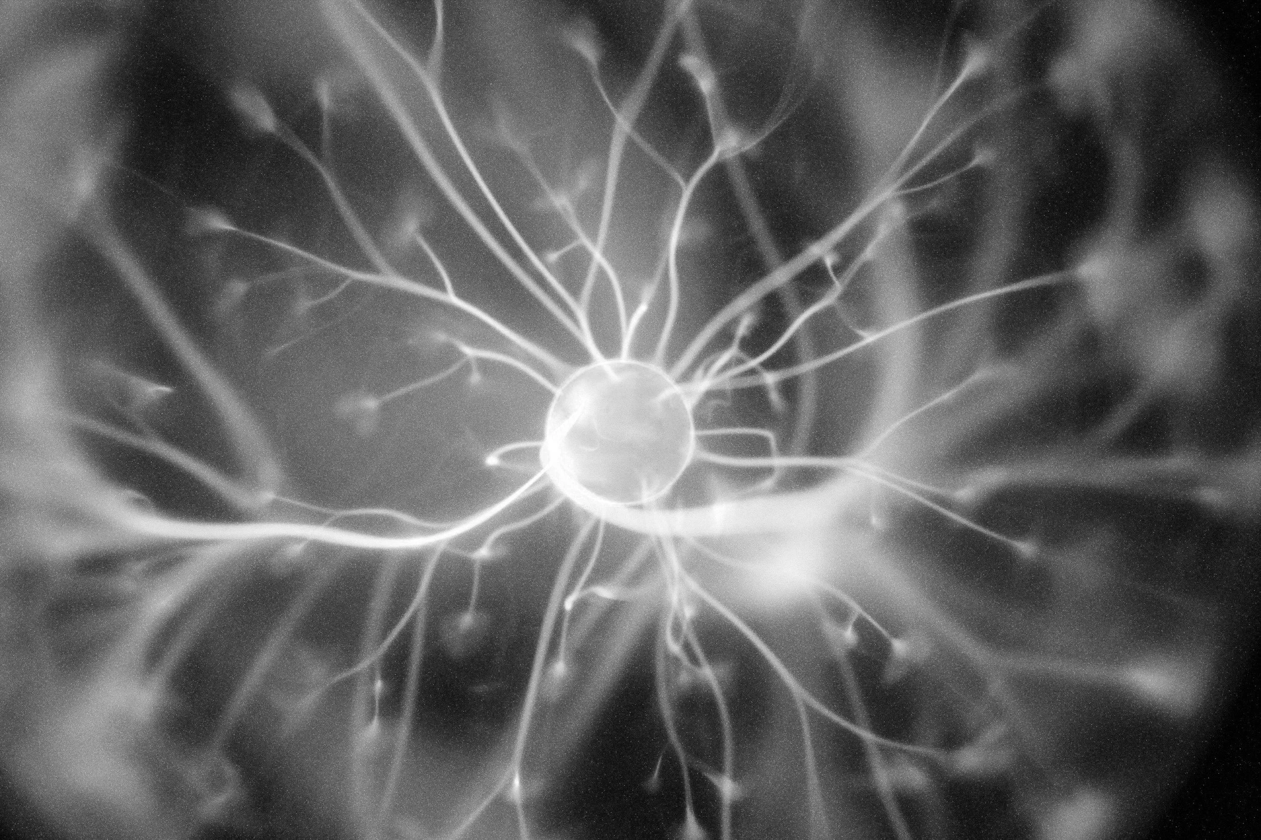 Black and white close-up image of a bolt of static electricity, with electric sparks radiating from a central point.